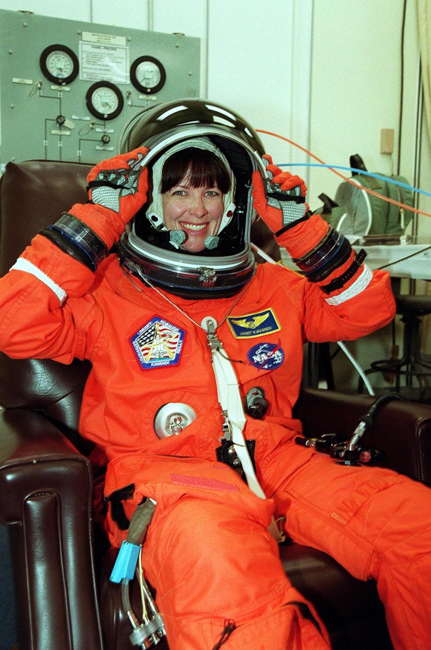 KENNEDY SPACE CENTER, Fla. -- STS-104 Mission Specialist Janet Lynn Kavandi adjusts her helmet as she dons her launch and entry suit before heading to the launch pad. This launch will be her third space flight. Liftoff of Space Shuttle Atlantis on mission STS-104 is targeted for 5:04 a.m., July 12, from Launch Pad 39B. The primary payload on the mission is the joint airlock module, which will be added to the International Space Station. The airlock will be the primary path for Space Station spacewalk entry and departure for U.S. spacesuits, and will also support the Russian Orlan spacesuit for EVA activity