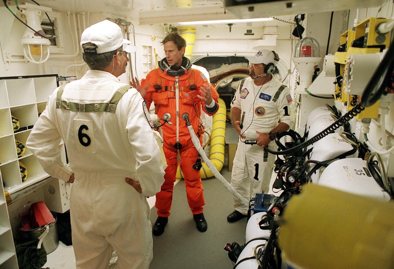 KENNEDY SPACE CENTER, Fla. -- In the White Room, STS-104 Mission Specialist Michael L. Gernhardt (center) talks to closeout crew members before entering Space Shuttle Atlantis. The White Room is an environmental chamber at the end of the Orbiter Access Arm that provides entry into the orbiter on the launch pad. Atlantis lifted off from Launch Pad 39B on time at 5:03:59 a.m. EDT. The 10th assembly flight to the International Space Station, the primary payload on the mission is the joint airlock module, which will require two spacewalks to attach it to the Space Station. The airlock will be the primary path for Space Station spacewalk entry and departure for U.S. spacesuits, and will also support the Russian Orlan spacesuit for EVA activity