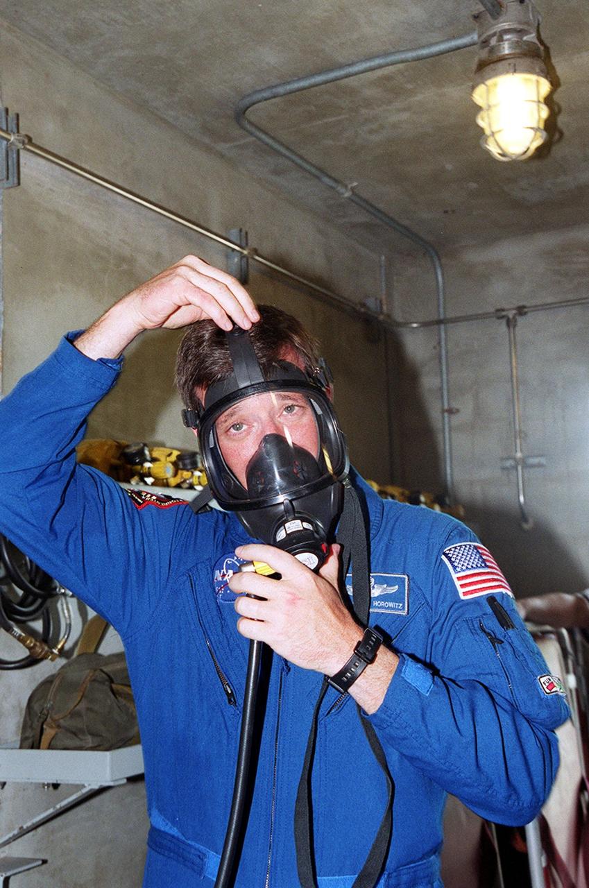 KENNEDY SPACE CENTER, Fla. -- At Launch Pad 39A, STS-105 Commander Scott Horowitz puts on a gas mask as part of Terminal Countdown Demonstration Test activities, which also include emergency egress, a simulated launch countdown and familiarization with the payload. Mission STS-105 will be transporting the Expedition Three crew, several payloads and scientific experiments to the International Space Station aboard Space Shuttle Discovery. The current Expedition Two crew members on the Station will return to Earth on Discovery. Launch is scheduled no earlier than Aug. 9, 2001
