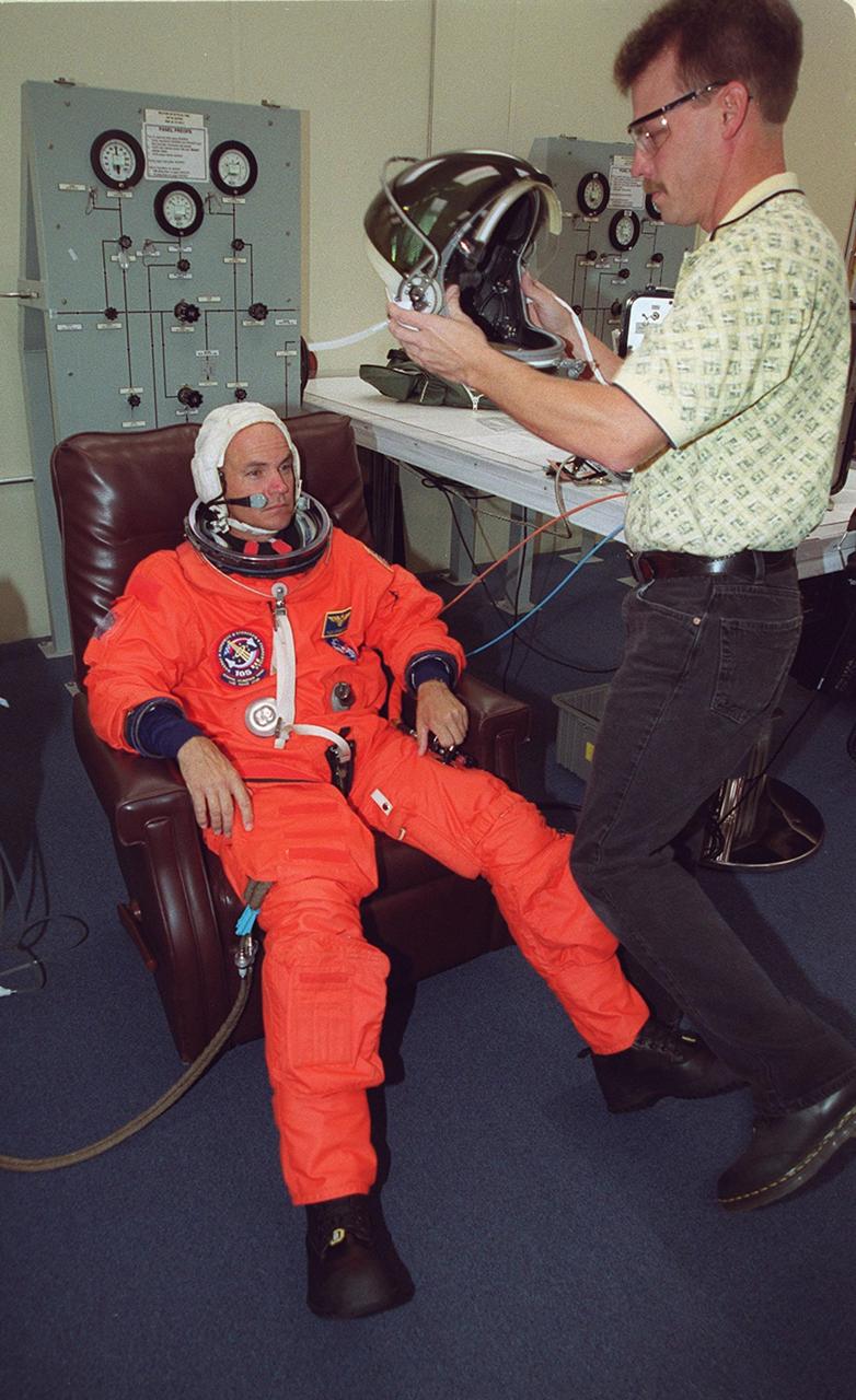 KENNEDY SPACE CENTER, Fla. -- STS-105 Pilot Rick Sturckow waits for his helmet during suit check before heading to Launch Pad 39A. The STS-105 and Expedition Three crews are at Kennedy Space Center participating in a Terminal Countdown Demonstration Test, a dress rehearsal for launch. The activities include emergency egress training, a simulated launch countdown and familiarization with the payload. Mission STS-105 will be transporting the Expedition Three crew, several payloads and scientific experiments to the International Space Station aboard Space Shuttle Discovery. The Expedition Two crew members currently on the Station will return to Earth on Discovery. The mission is scheduled to launch no earlier than Aug. 9, 2001