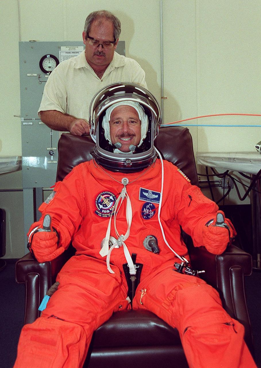 KENNEDY SPACE CENTER, Fla. -- STS-105 Commander Scott Horowitz finishes with suit check before heading to Launch Pad 39A. The STS-105 and Expedition Three crews are at Kennedy Space Center participating in a Terminal Countdown Demonstration Test, a dress rehearsal for launch. The activities includes emergency egress training, a simulated launch countdown and familiarization with the payload. Mission STS-105 will be transporting the Expedition Three crew, several payloads and scientific experiments to the International Space Station aboard Space Shuttle Discovery. The Expedition Two crew members currently on the Station will return to Earth on Discovery. The mission is scheduled to launch no earlier than Aug. 9, 2001
