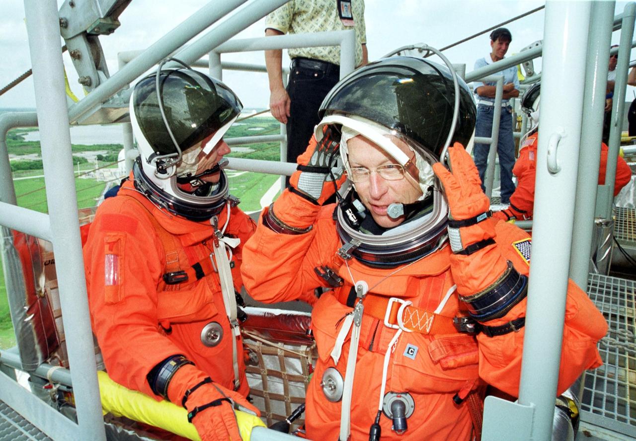 KENNEDY SPACE CENTER, Fla. -- STS-105 Mission Specialists Daniel Barry (left) and Patrick Forrester (right) wait in the slidewire basket that is part of the emergency egress system. The STS-105 and Expedition Three crews are at Kennedy Space Center participating in a Terminal Countdown Demonstration Test, a dress rehearsal for launch. The activities also include a simulated launch countdown and familiarization with the payload. Mission STS-105 will be transporting the Expedition Three crew, several payloads and scientific experiments to the International Space Station aboard Space Shuttle Discovery. The Expedition Two crew members currently on the Station will return to Earth on Discovery. The mission is scheduled to launch no earlier than Aug. 9, 2001