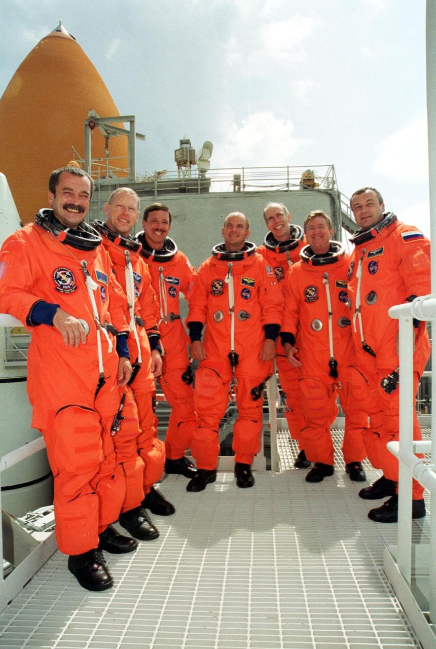 KENNEDY SPACE CENTER, Fla. -- The STS-105 and Expedition Three crews pose on the Fixed Service Structure at Launch Pad 39A. From left are cosmonaut Mikhail Tyurin, Mission Specialist Patrick Forrester, Commander Scott Horowitz, Pilot Rick Sturckow, Mission Specialist Daniel Barry, ISS Commander Frank Culbertson and cosmonaut Vladimir Nikolaevich Dezhurov. Both crews are at Kennedy Space Center participating in a Terminal Countdown Demonstration Test, a dress rehearsal for launch. The activities include emergency egress training, a simulated launch countdown and familiarization with the payload. Mission STS-105 will be transporting the Expedition Three crew, several payloads and scientific experiments to the International Space Station aboard Space Shuttle Discovery. The Expedition Two crew members currently on the Station will return to Earth on Discovery. The mission is scheduled to launch no earlier than Aug. 9, 2001