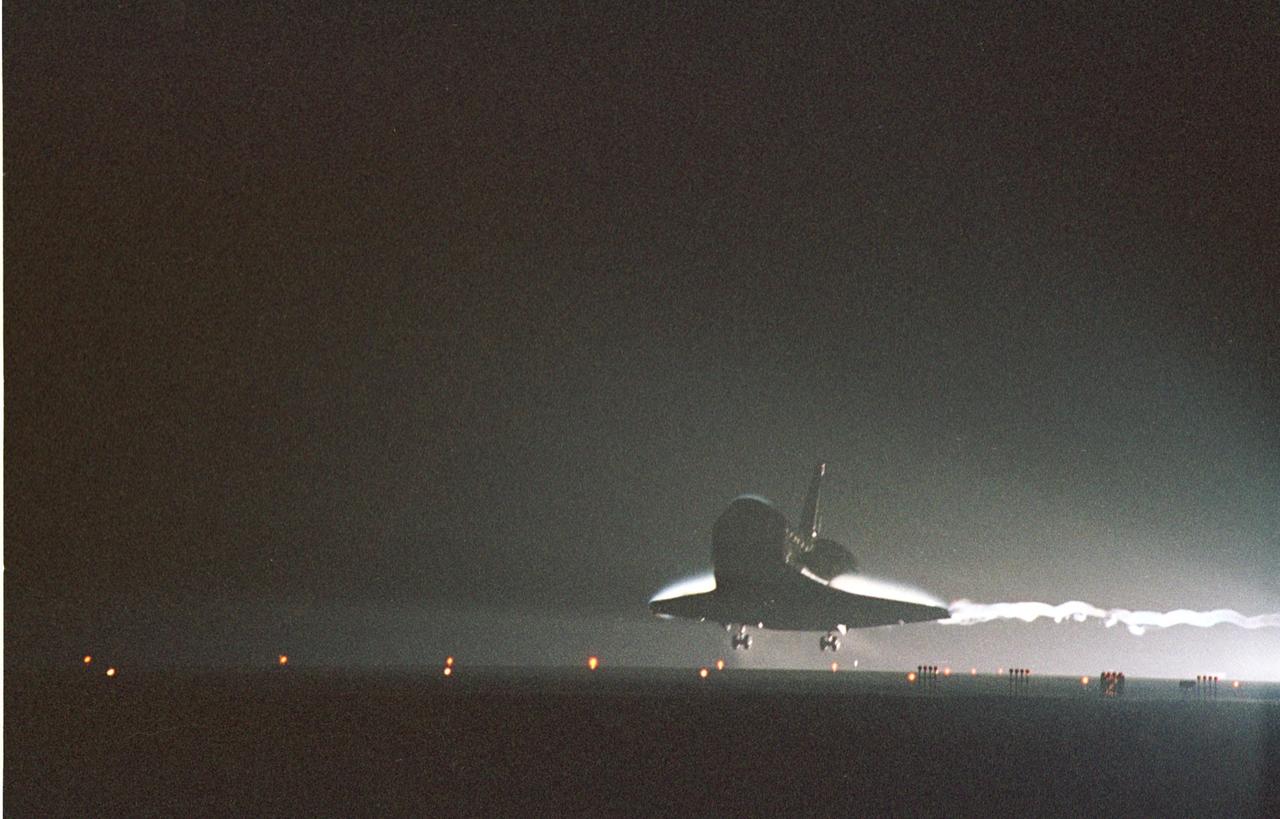 KENNEDY SPACE CENTER, Fla. -- Silhouetted against the bright lights at the Shuttle Landing Facility, Atlantis prepares to land on Runway 15 at the Shuttle Landing Facility to complete a 12-day, 18-hour, 34-minute-long STS-104 mission. Main gear touchdown occurred at 11:38:55 p.m. EDT. At the controls is Commander Steven W. Lindsey. Other crew members on board are Pilot Charles Hobaugh and Mission Specialists Michael Gernhardt, Janet Lynn Kavandi and James F. Reilly. This is the 18th nighttime landing for a Space Shuttle, the 13th at Kennedy Space Center. The mission delivered the Joint Airlock Module to the International Space Station, completing the second phase of the assembly of the Space Station