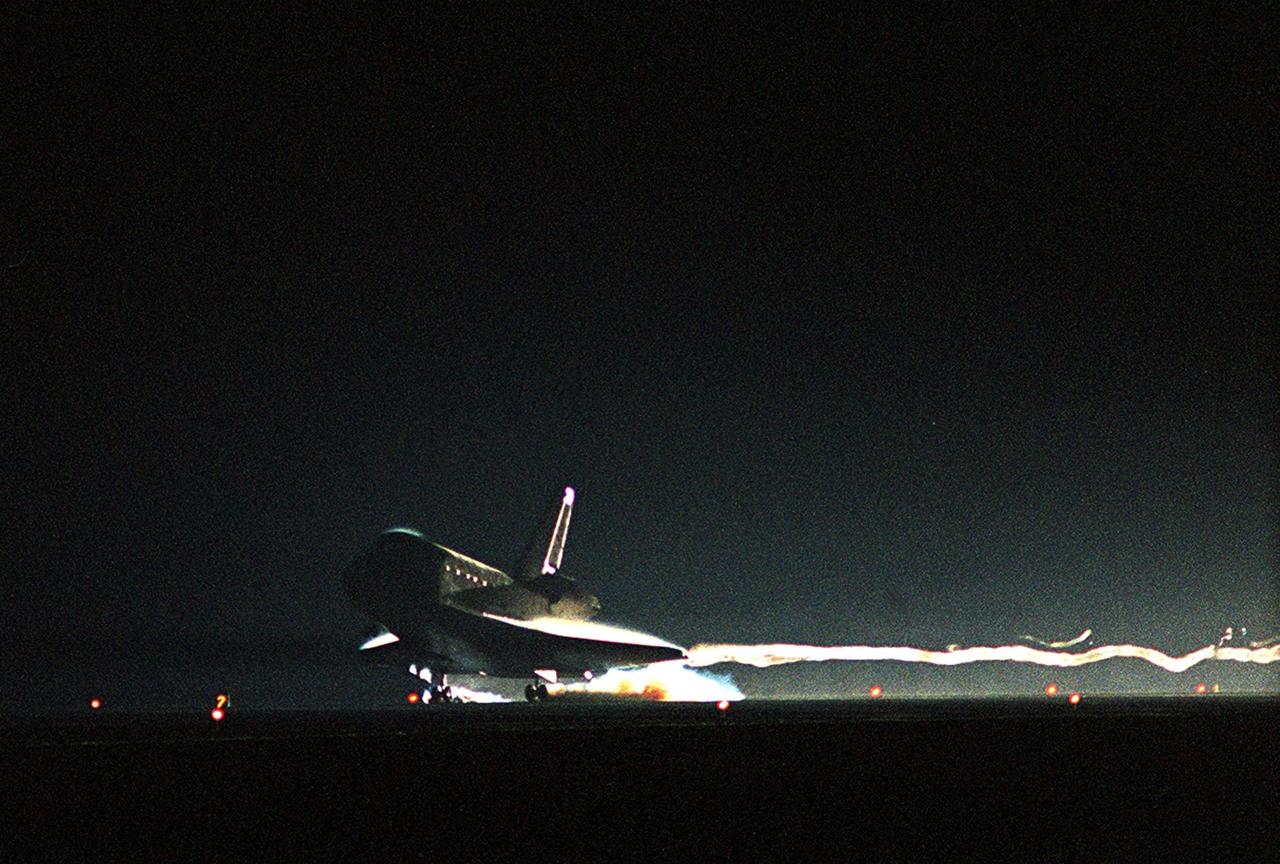 KENNEDY SPACE CENTER, Fla. -- Air waves stream behind Atlantis as it touches down on Runway 15 at the KSC Shuttle Landing Facility. Main gear touchdown occurred at 11:38:55 p.m. EDT, completing complete a 12-day, 18-hour, 34-minute-long STS-104 mission. At the controls is Commander Steven W. Lindsey. Other crew members on board are Pilot Charles Hobaugh and Mission Specialists Michael Gernhardt, Janet Lynn Kavandi and James F. Reilly. This is the 18th nighttime landing for a Space Shuttle, the 13th at Kennedy Space Center. The mission delivered the Joint Airlock Module to the International Space Station, completing the second phase of the assembly of the Space Station