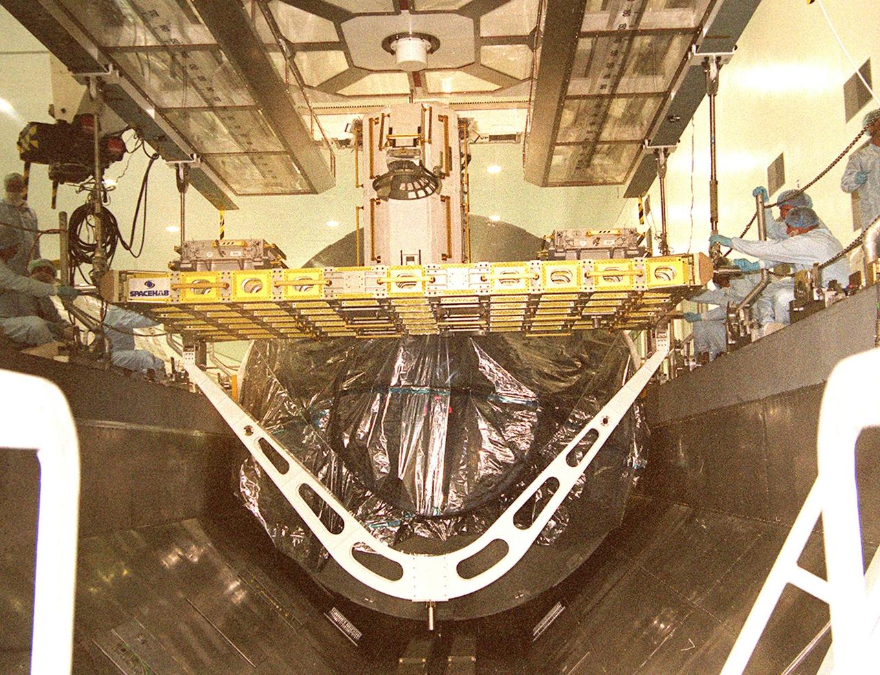 KENNEDY SPACE CENTER, Fla. -- The Integrated Cargo Carrier is lowered into the payload canister in front of the Multi-Purpose Logistics Module Leonardo. The ICC holds several payloads for mission STS-105, the Early Ammonia Servicer and two experiment containers. The canister will transport the MPLM and ICC transport to Launch Pad 39A where they will be placed in the payload bay of Space Shuttle Discovery. Launch of STS-105 is scheduled for 5:38 p.m. EDT Aug. 9
