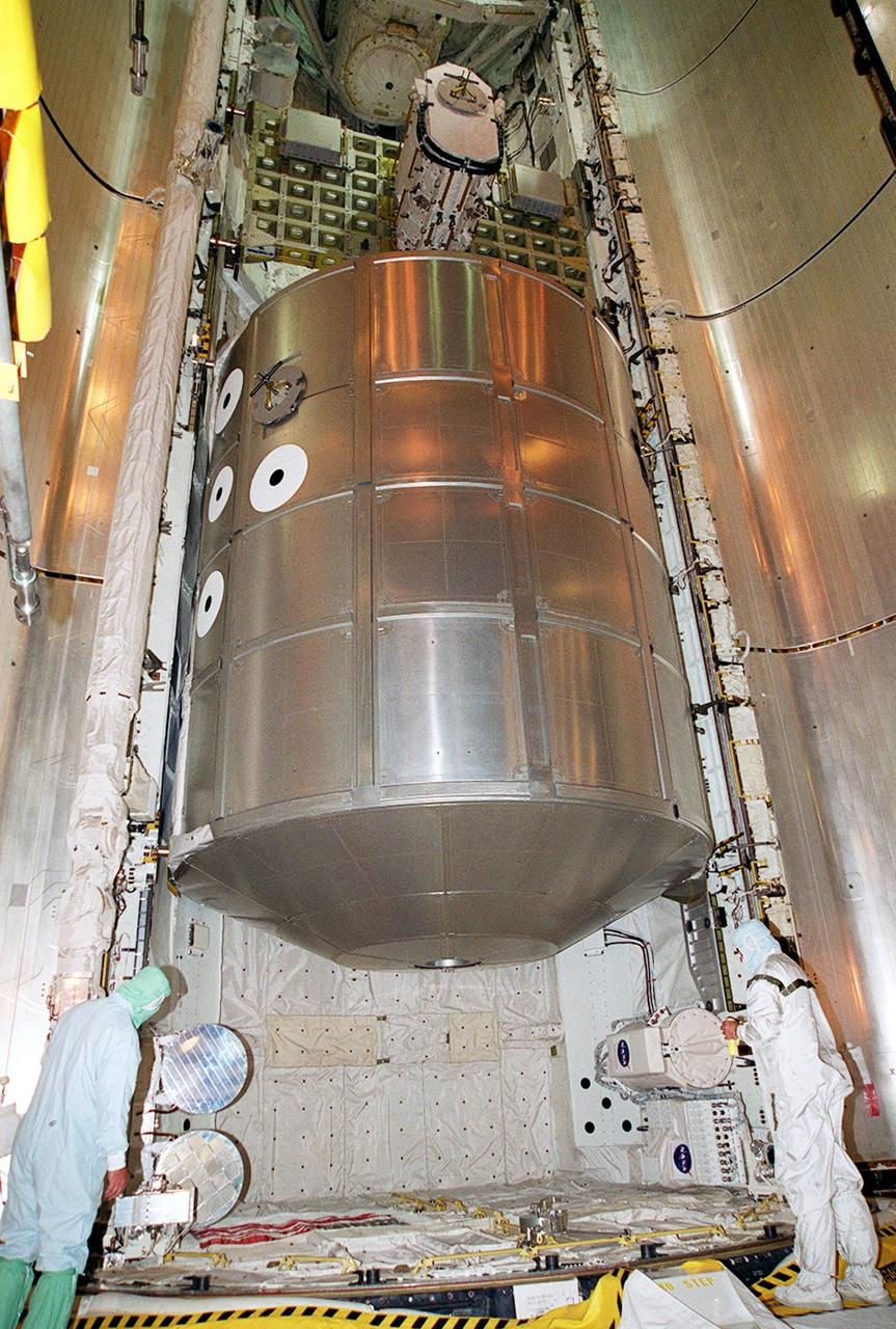 KENNEDY SPACE CENTER, Fla. -- On Launch Pad 39A, workers check out the loading of the payloads into Discovery’s payload bay. In the center is the Multi-Purpose Logistics Module Leonardo, filled with laboratory racks of science equipment and racks and platforms of experiments and supplies. Above Leonardo is the Integrated Cargo Carrier with the Early Ammonia Servicer (EAS) in the center. The EAS contains spare ammonia for the Station’s cooling system. Ammonia is the fluid used in the radiators that cool the Station’s electronics. The EAS will be installed on the P6 truss holding the giant U.S. solar arrays, batteries and cooling radiators. Seen below the MPLM and attached on the port and starboard adapter beams are experiments. Discovery is scheduled to be launched Aug. 9, 2001