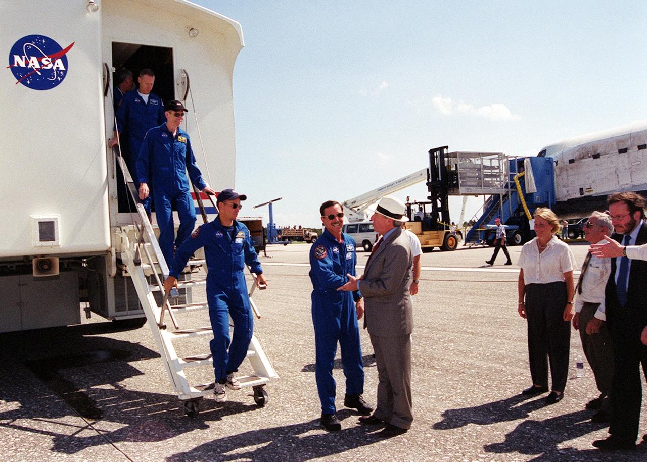 KENNEDY SPACE CENTER, Fla. - As members of the STS-105 crew exit the Crew Transfer Vehicle (CTV) following Discovery's landing on KSC's Shuttle Landing Facility runway 15, they are greeted by NASA Administrator Dan Goldin. From left are Mission Specialists Patrick Forrester and Daniel Barry, Pilot Frederick "Rick" Sturckow, and Commander Scott "Doc" Horowitz (shaking hands with Goldin).  Looking on are, from left, Kathie Olsen, NASA chief scientist; Joe Rothenberg, associate administrator, Office of Space Flight; and Courtney Stadd, NASA Headquarters chief of staff.  Main gear touchdown was at 2:22:58 p.m. EDT; wheel stop, at 2:24:06 p.m. EDT. The 11-day, 21-hour, 12-minute STS-105 mission accomplished the goals set for the 11th flight to the International Space Station: swapout of the resident Station crew; delivery of equipment, supplies and scientific experiments; and installation of the Early Ammonia Servicer and heater cables for the S0 truss on the Station. Discovery traveled 4.3 million miles on its 30th flight into space, the 106th mission of the Space Shuttle program. Out of five missions in 2001, the landing was the first to occur in daylight at KSC. 