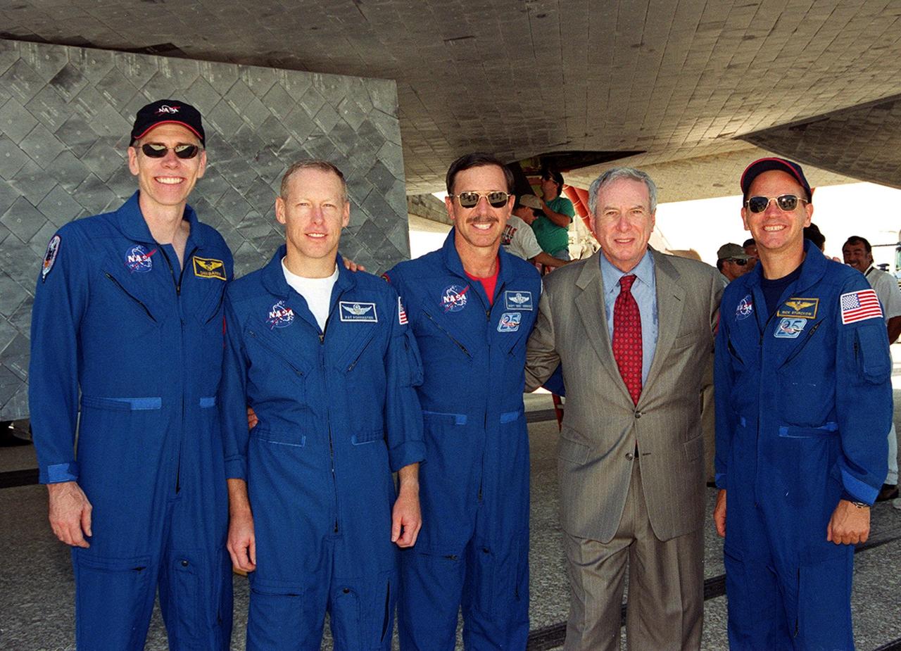 KENNEDY SPACE CENTER, Fla. - Following the landing of mission STS-105, the crew poses with NASA Administrator Daniel Goldin under Space Shuttle Discovery on KSC's Shuttle Landing Facility runway 15. From left are Mission Specialists Daniel Barry and Patrick Forrester, Commander Scott "Doc" Horowitz, Administrator Goldin, and Pilot Frederick "Rick" Sturckow. Main gear touchdown was at 2:22:58 p.m. EDT; wheel stop, at 2:24:06 p.m. EDT. The 11-day, 21-hour, 12-minute STS-105 mission accomplished the goals set for the 11th flight to the International Space Station: swapout of the resident Station crew; delivery of equipment, supplies and scientific experiments; and installation of the Early Ammonia Servicer and heater cables for the S0 truss on the Station. Discovery traveled 4.3 million miles on its 30th flight into space, the 106th mission of the Space Shuttle program. Out of five missions in 2001, the landing was the first to occur in daylight at KSC.