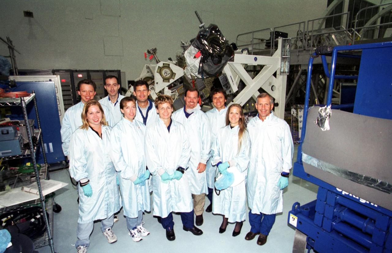 KENNEDY SPACE CENTER, Fla. -- The STS-111 crew spend time in the Space Station Processing Facility learning more about the payload they will be transporting: The Mobile Base System (MBS).   Standing left to right in the back row are Expedition Five Commander Valeri Kozun, with the Russian Aviation and Space Agency; Mission Specialist Phillippe Perrin, with the French space agency CNES; Pilot Paul Lockhart; trainer Chris Hardcastle; Mission Specialist Franklin Chang-Diaz; and Commander Ken Cockrell.  Flanked by trainers in the front row is (center) Peggy Whitson, another of the Expedition Five crew who will ferried to the International Space Station.  The MBS will be installed on the Mobile Transporter to complete the Canadian Mobile Servicing System, or MSS. The mechanical arm will then have the capability to "inchworm" from the U.S. Lab Destiny to the MSS and travel along the Truss to work sites.  The Expedition Five crew will be replacing Expedition Four.  Launch of Endeavour on mission STS-111 is scheduled for April 18, 2002