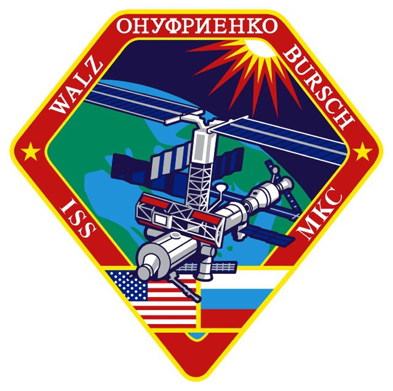 JOHNSON SPACE CENTER, HOUSTON, TEXAS -- EXPEDITION FOUR INSIGNIA -- The International Space Station (ISS) Expedition Four crew patch has an overall diamond shape, showing the "diamond in the rough" configuration of the Station during expedition four.  The red hexagonal shape with stylized American and Russian flags represents the cross-sectional view of the S0 truss segment, which the crew will attach to the U.S. Lab Destiny.  The persistent Sun shining on the Earth and Station represents the constant challenges that the crew and ground support team will face every day while operating the International Space Station, while shedding new light through daily research.  The green portion of the Earth represents the fourth color in the visible spectrum and the black void of space represents humankind's constant quest to explore the unknown.    The NASA insignia design for Shuttle flights ts is reserved for use by the astronauts  and for other official use as the NASA Administrator may authorize.  Public availability has been approved only in the forms of illustrations by the various news media.  When and if there is any change in this policy, which we do not anticipate, it will be publicly announced