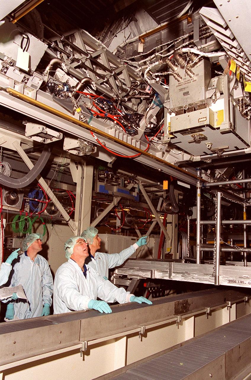 KENNEDY SPACE CENTER, Fla. --  From a vantage point below it, members of the STS-110 crew check out Integrated Truss Structure (ITS) S0, which is in the Operations and Checkout Building.  From left are Mission Specialists Rex J. Walheim, Jerry L. Ross and Lee M. Morin.  They and other crew members are taking part in a Crew Equipment Interface Test at KSC.   Not shown are Commander Michael J. Bloomfield, Pilot Stephen N. Frick, and Mission Specialists Steven L. Smith and Ellen Ochoa. The ITS S0 is part of the payload on the mission. It is the center segment they will be installing on the International Space Station, part of the 300-foot (91-meter) truss attached to the U.S. Lab. By assembly completion, four more truss segments will attach to either side of the S0 truss.  STS-110 is currently scheduled to launch in February 2002