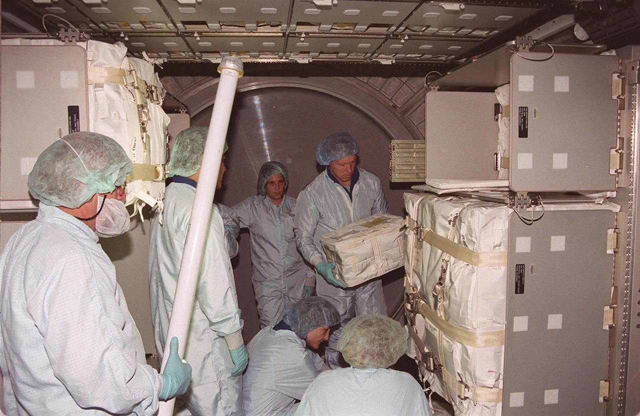 KENNEDY SPACE CENTER, Fla. --  The STS-108 crew practices moving packages in storage inside the the Multi-Purpose Logistics Module Raffaello.  Holding a package is Commander Dominic L. Gorie.  Kneeling below him (center) is Mission Specialist Linda A. Godwin.  The crew is taking part in Crew Equipment Interface Test (CEIT) activities at KSC.  Not seen are Pilot Mark E. Kelly and Mission Specialist Daniel M. Tani. The CEIT provides familiarization with the launch vehicle and payload.  Mission STS-108 is a Utilization Flight (UF-1), carrying the Expedition Four crew plus Multi-Purpose Logistics Module Raffaello to the International Space Station.  The Expedition Four crew comprises Yuri Onufriyenko, commander, Russian Aviation and Space Agency, and astronauts Daniel W. Bursch and Carl E. Walz. Endeavour is scheduled to launch Nov. 29 on mission STS-108