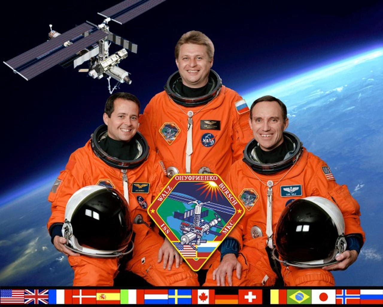 JOHNSON SPACE CENTER, HOUSTON, TEXAS -- EXPEDITION FOUR CREW PORTRAIT -- (ISS04-5-002) -- Expedition Four crew members take a break from training for their scheduled upcoming stay aboard the International Space Station (ISS) to pose for the traditional pre-flight crew portrait.  Cosmonaut Yuri I. Onufrienko (standing at center), mission commander, is flanked by astronauts Daniel W. Bursch (left) and Carl E. Walz, both flight engineers.  The national flags of the International Partners are at the bottom of the portrait