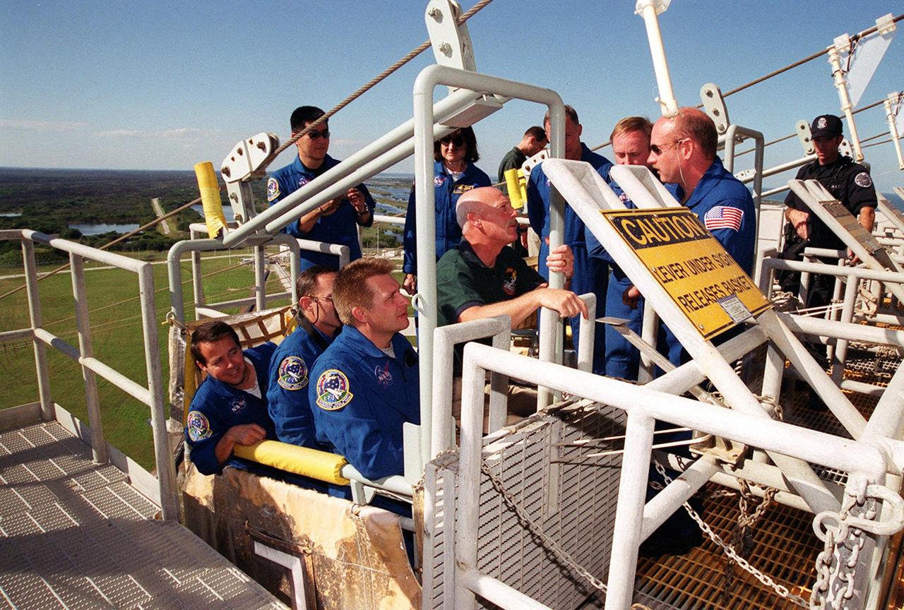 KENNEDY SPACE CENTER, Fla. --  On Launch Pad 39B, the STS-108 crew, Expedition 4 and a backup crew are trained in using the emergency egress system.  In the slidewire basket (foreground) are Expedition 4 members (left to right) Daniel W. Bursch, Carl E. Walz and Commander Yuri Onufrienko.  Seen in the background are STS-108 Mission Specialists Daniel M. Tani and Linda A. Godwin, Commander Dominic L. Gorie, backup crew member Michael Fincke, and Pilot Mark E. Kelly. Crew members are at KSC for Terminal Countdown Demonstration Test activities that include a simulated launch countdown, plus the emergency exit training from the orbiter and launch pad. STS-108 is a Utilization Flight that will carry the replacement Expedition 4 crew to the International Space Station, as well as the Multi-Purpose Logistics Module Raffaello, filled with supplies and equipment.  The l1-day mission is scheduled for launch Nov. 29 on Space Shuttle Endeavour