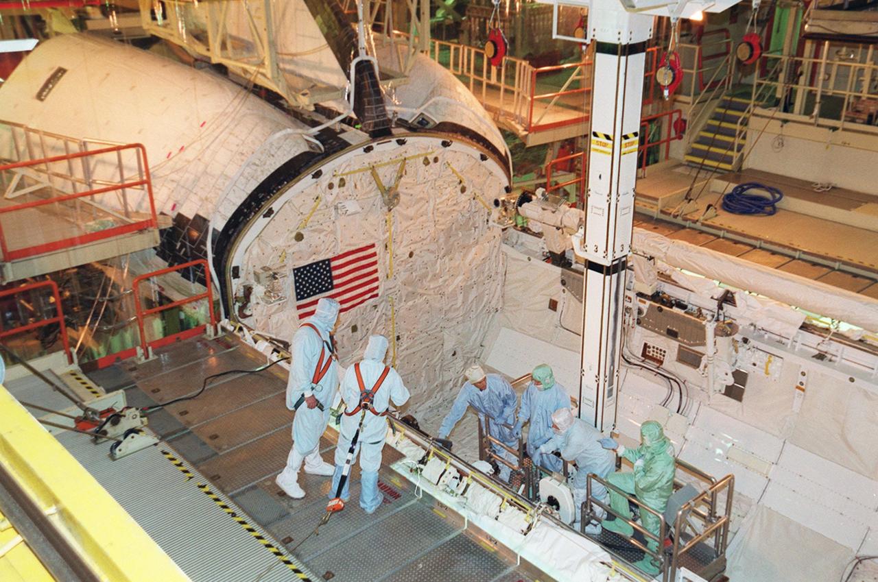KENNEDY SPACE CENTER, Fla. -  Members of the STS-109 crew are lowered into the payload bay of orbiter Columbia to check out some of the equipment. The crew is at KSC to take part in Crew Equipment Interface Test activities that include familiarization with the orbiter and equipment. The goal of the mission is to service the HST, replacing Solar Array 2 with Solar Array 3, replacing the Power Control Unit, removing the Faint Object Camera and installing the Advanced Camera for Surveys, installing the Near Infrared Camera and Multi-Object Spectrometer (NICMOS) Cooling System, and installing New Outer Blanket Layer insulation on bays 5 through 8.  Mission STS-109 is scheduled for launch Feb. 14, 2002