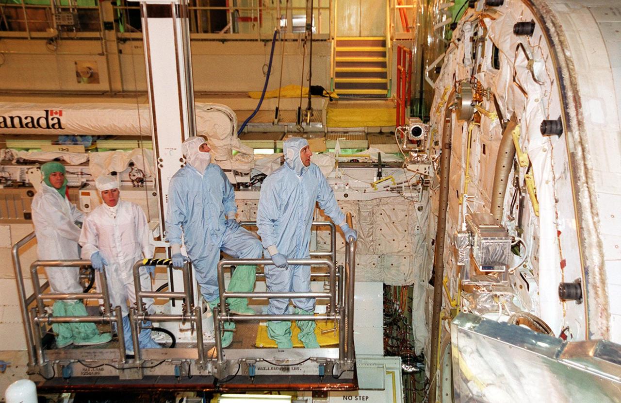KENNEDY SPACE CENTER, Fla. - Members of the STS-109 crew look over the interior of orbiter Columbia's payload bay. At right is Mission Specialist Michael Massimino; next to him is Commander Scott Altman. The crew is at KSC to take part in Crew Equipment Interface Test activities that include familiarization with the orbiter and equipment. The goal of the mission is to service the HST, replacing Solar Array 2 with Solar Array 3, replacing the Power Control Unit, removing the Faint Object Camera and installing the Advanced Camera for Surveys, installing the Near Infrared Camera and Multi-Object Spectrometer (NICMOS) Cooling System, and installing New Outer Blanket Layer insulation on bays 5 through 8. Mission STS-109 is scheduled for launch Feb. 14, 2002