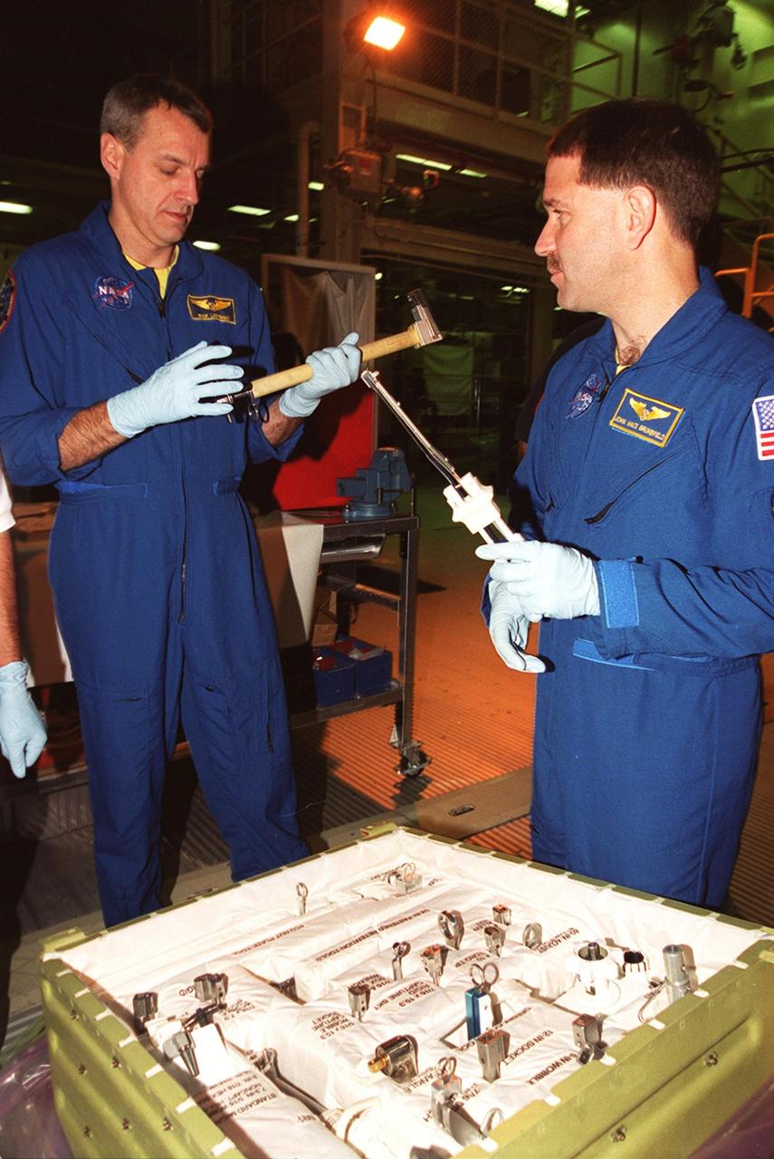 KENNEDY SPACE CENTER, Fla. - STS-109 Mission Specialist Richard Lennehan (left) and Payload Commander John Grunsfeld get a feel for tools and equipment that will be used on the mission. The crew is at KSC to take part in Crew Equipment Interface Test activities that include familiarization with the orbiter and equipment. The goal of the mission is to service the HST, replacing Solar Array 2 with Solar Array 3, replacing the Power Control Unit, removing the Faint Object Camera and installing the Advanced Camera for Surveys, installing the Near Infrared Camera and Multi-Object Spectrometer (NICMOS) Cooling System, and installing New Outer Blanket Layer insulation on bays 5 through 8. Mission STS-109 is scheduled for launch Feb. 14, 2002