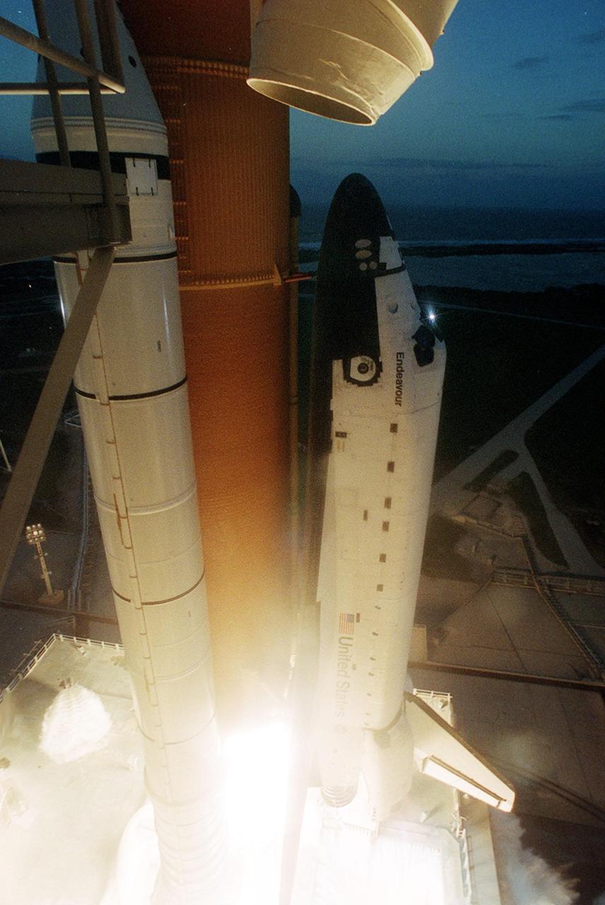KENNEDY SPACE CENTER, FLA. -- Just before sunset, Space Shuttle Endeavour lifts off Launch Pad 39B at 5:19:28 p.m. EST (22:19:28 GMT) on mission STS-108. At left can be seen one of the six 12-foot-high rainbirds circling the Shuttle on the mobile launcher platform. Part of the sound suppression system, when solid rocket booster ignition and liftoff occur, a torrent of water flows onto the MLP from the rainbirds. Acoustical levels reach their peak when the Space Shuttle is about 300 feet above the MLP. Beyond the Shuttle can be seen part of the Banana Creek. Endeavour will dock with the International Space Station on Dec. 7. STS-108 is the final Shuttle mission of 2001and the 107th Shuttle flight overall. It is the 12th flight to the Space Station. Landing of the orbiter at KSC's Shuttle Landing Facility is targeted for 1:05 p.m. EST (18:05 p.m. GMT) Dec. 16