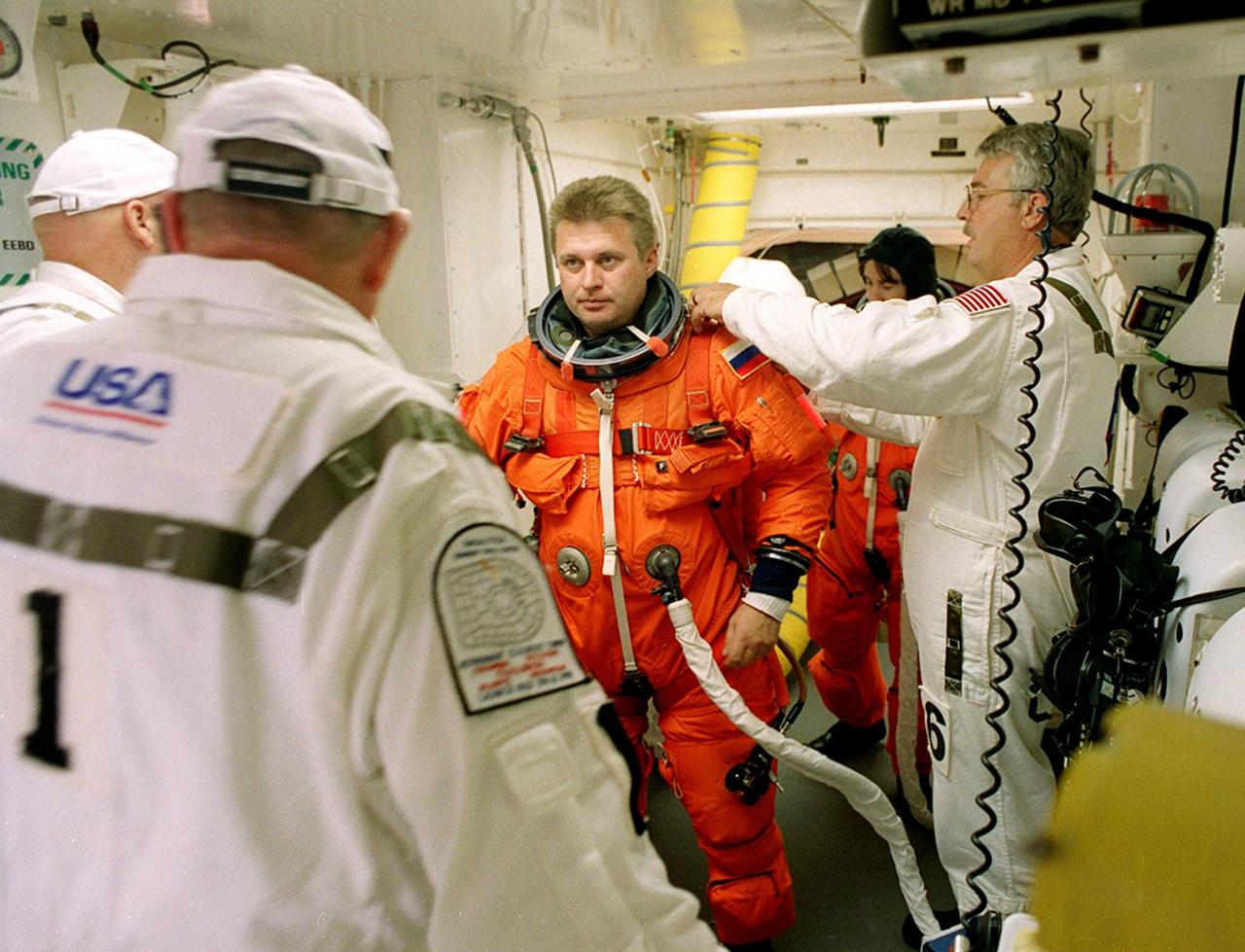 KENNEDY SPACE CENTER, Fla. - Expedition 4 Commander Yuri Onufrienko gets help with his launch and entry suit before entering Endeavour. The main goals of the mission are to carry the Expedition 4 crew to the International Space Station as replacement for Expedition 3; carry the Multi-Purpose Logistics Module Raffaello filled with water, equipment and supplies; and install thermal blankets over equipment at the base of the ISS solar wings. STS-108 is the final Shuttle mission of 2001 and the 107th Shuttle flight overall. It is the 12th flight to the Space Station. Launch is scheduled for 5:19 p.m. EST (22:19 GMT) Dec. 5, 2001, from Launch Pad 39B