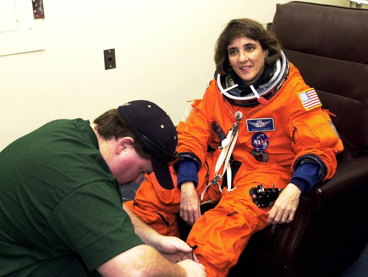 KENNEDY SPACE CENTER, FLA.  - STS-109 Mission Specialist Nancy Currie gets a suit check during Terminal Countdown Demonstration Test activities.   She and other crew members - Commander Scott Altman, Pilot Duane Carey, Payload Commander John Grunsfeld and Mission Specialists James Newman, Richard Linnehan and Michael Massimino - are at Kennedy for the TCDT that also includes emergency egress training and a simulated countdown.  Columbia is scheduled to be launched Feb. 28 on mission STS-109, a Hubble Servicing Mission. The goal of the mission is to replace Solar Array 2 with Solar Array 3, replace the Power Control Unit, remove the Faint Object Camera and install the ACS, install the Near Infrared Camera and Multi-Object Spectrometer (NICMOS) Cooling System, and install New Outer Blanket Layer insulation.  The launch will be the first for Columbia after returning from California where it underwent extensive maintenance, inspections and enhancements. More than 100 upgrades make Columbia safer and more reliable than ever before