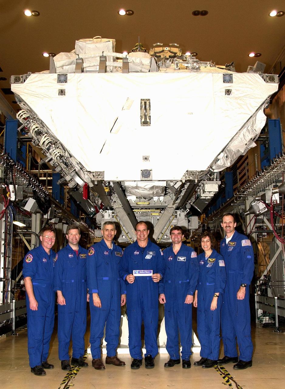 KENNEDY SPACE CENTER, FLA. --  The STS-110 crew poses under the Integrated Truss Structure S0, ready for transport to the launch pad.   Standing left to right are Mission Specialist Jerry Ross, Pilot Stephen Frick, Mission Specialist Lee Morin, Commander Michael Bloomfield, and Mission Specialists Rex Walheim, Ellen Ochoa and Steven Smith.  Scheduled for launch April 4, the 11-day STS-110 mission will feature Space Shuttle Atlantis docking with the International Space Station (ISS) and delivering the S0 truss, the centerpiece-segment of the primary truss structure that will eventually extend over 300 feet. 