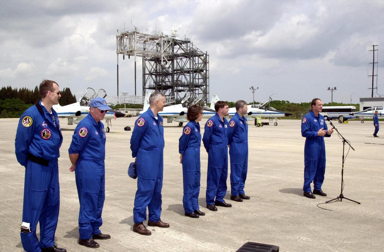 KENNEDY SPACE CENTER, FLA. --  After landing at the KSC Shuttle Landing Facility to prepare for launch April 4, the STS-110 crew pauses for a photo and a few words to the media.  Standing left to right are Mission Specialists Steven Smith, Jerry Ross, Lee Morin, Ellen Ocho and Rex Walheim; Pilot Stephen Frick; and Commander Michael Bloomfield at the microphone. Mission STS-110 is the 13th assembly flight to the International Space Station.  During four planned spacewalks, crew members will install the S0 Integrated Truss Structure (ITS), centerpiece of the orbiting International Space Station (ISS), at the center of the 10-truss, girderlike structure that will ultimately extend the length of a football field on the ISS.   The S0 truss will be attached to the U.S. Lab, "Destiny,"  on the 11-day mission