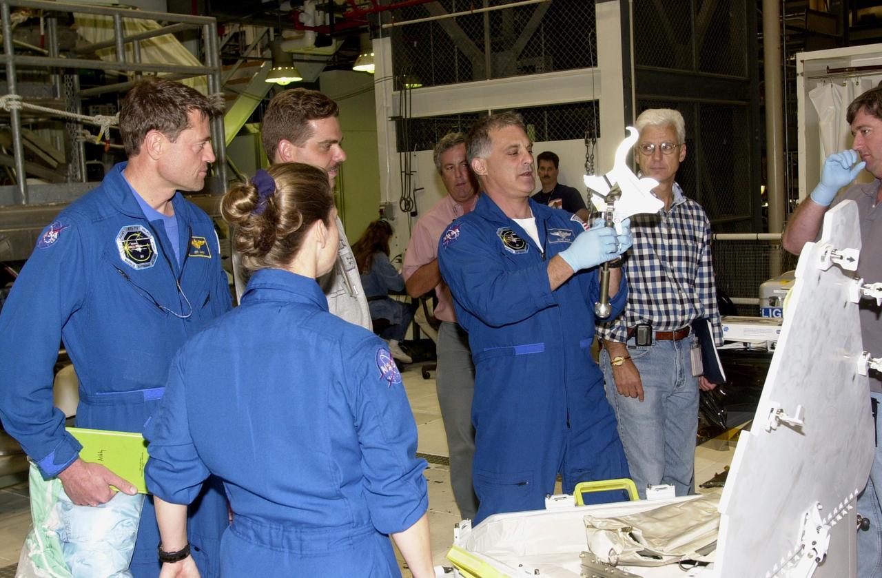 KENNEDY SPACE CENTER, FLA. --  Members of the STS-112 crew check out flight equipment during a Crew Equipment Interface Test at KSC.  Clockwise from front are Pilot Pamela Melroy, Commander Jeffrey Ashby, a technician, and Mission Specialist David Wolf. STS-112 is the 15th assembly flight to the International Space Station and will be ferrying the S1 Integrated Truss Structure. The S1 truss is the first starboard (right-side) truss segment, whose main job is providing structural support for the radiator panels that cool the Space Station's complex power system. The S1 truss segment also will house communications systems, external experiment positions and other subsystems.  The S1 truss will be attached to the S0 truss.  STS-112 is currently scheduled for launch Aug. 22, 2002