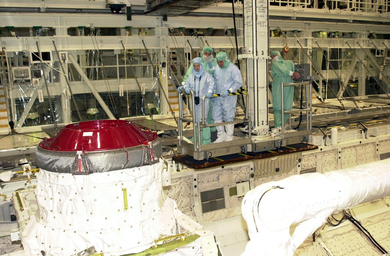 KENNEDY SPACE CENTER, FLA. -- Accompanied by a technician, STS-112 Pilot Pamela Melroy (left) and Mission Specialist David Wolf (right) look at the payload and equipment in the bay of Atlantis during a Crew Equipment Interface Test at KSC. STS-112 is the 15th assembly flight to the International Space Station and will be ferrying the S1 Integrated Truss Structure. The S1 truss is the first starboard (right-side) truss segment, whose main job is providing structural support for the radiator panels that cool the Space Station's complex power system. The S1 truss segment also will house communications systems, external experiment positions and other subsystems. The S1 truss will be attached to the S0 truss. STS-112 is currently scheduled for launch Aug. 22, 2002