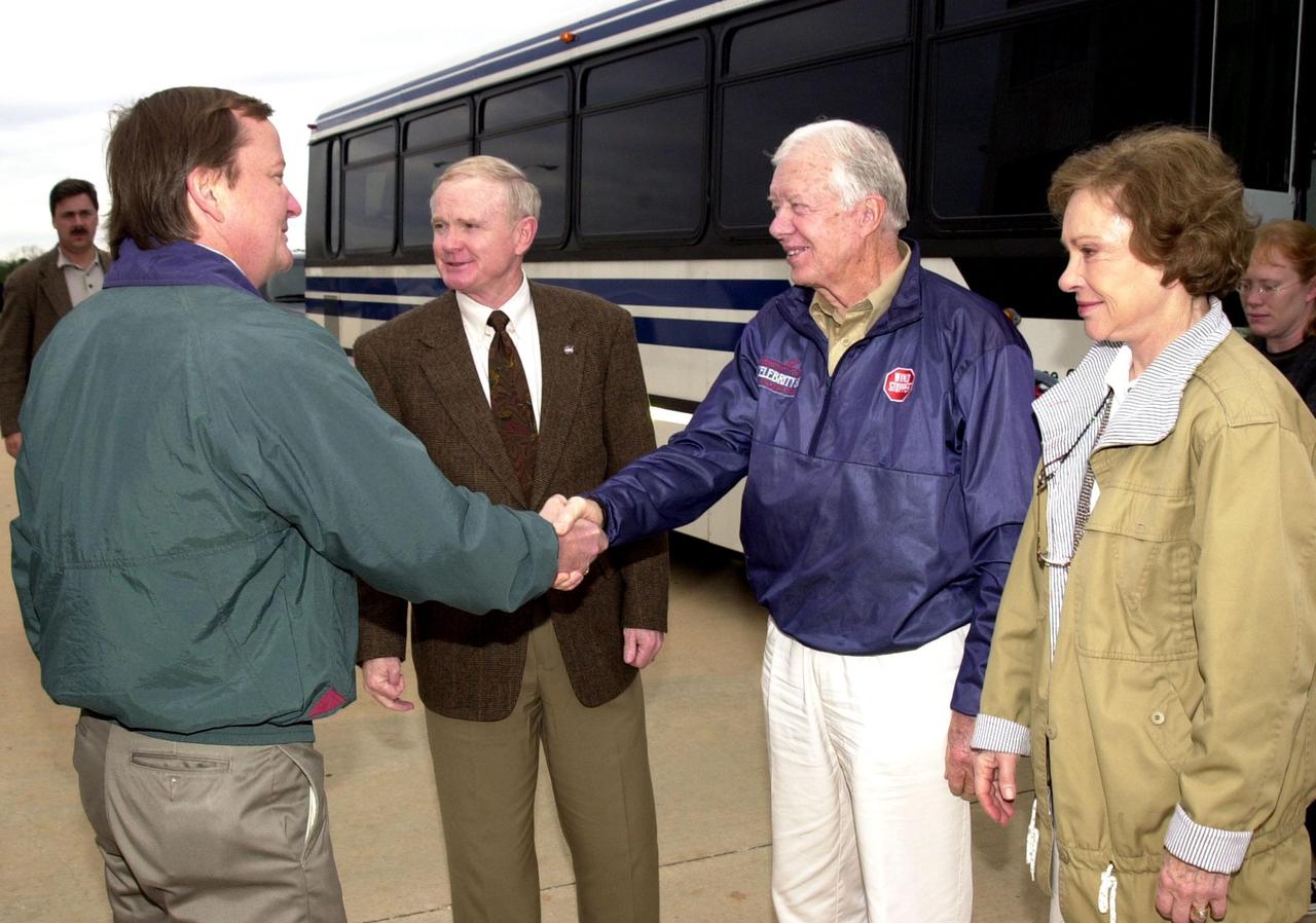KENNEDY SPACE CENTER, FLA. - Launch Director Mike Leinbach greets former President Jimmy Carter , who is touring Kennedy Space Center with his wife Rosalyn (right).  Center Director Roy D. Bridges Jr. stands between Leinbach and Carter