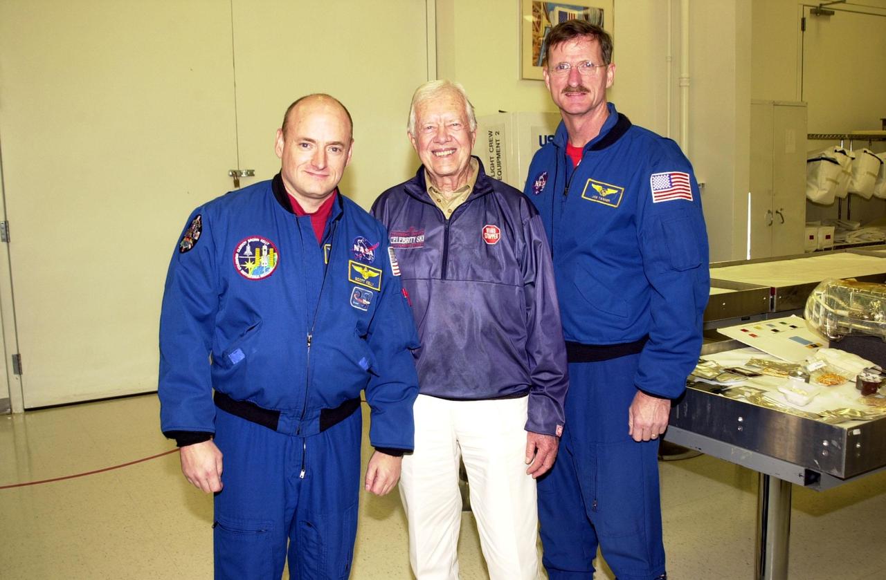 KENNEDY SPACE CENTER, FLA. -- In the Space Station Processing Facility, former President Jimmy Carter (center) pauses for a photo with astronauts Scott Kelly (left) and Joseph Tanner (right). Carter and former First Lady Rosalyn Carter are touring KSC