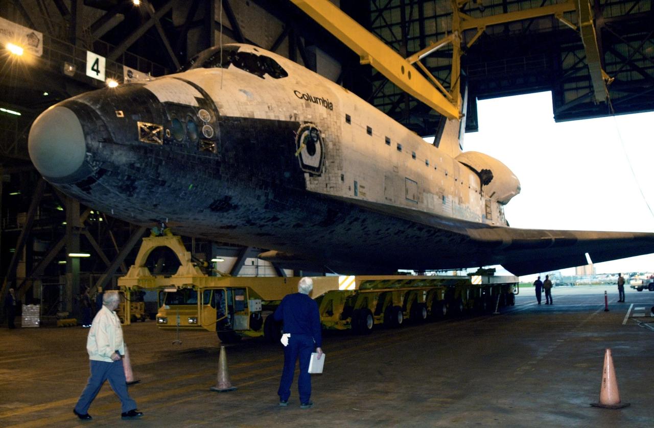 KENNEDY SPACE CENTER, FLA. --  In the Vehicle Assembly Building, overhead cranes are lowered toward the orbiter Columbia.  The cranes will lift the orbiter to a vertical position for stacking with the external tank and solid rocket boosters. Columbia is scheduled to be launched Feb. 28 on mission STS-109, a Hubble Servicing Mission. The goal of the mission is to service the HST, replacing Solar Array 2 with Solar Array 3, replacing the Power Control Unit, removing the Faint Object Camera and installing the ACS, installing the Near Infrared Camera and Multi-Object Spectrometer (NICMOS) Cooling System, and installing New Outer Blanket Layer insulation