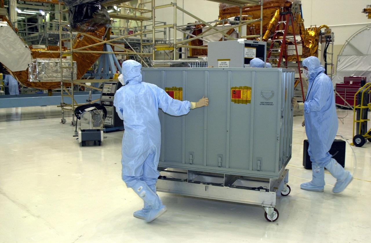 KENNEDY SPACE CENTER, FLA. -- Workers in the Vertical Processing Facility wheel a container with the NICMOS II across the floor. The Near Infrared Camera and Multi-Object Spectrometer (NICMOS) Cooling System is part of the payload on mission STS-109, the Hubble Servicing Telescope Mission. NICMOS is a new experimental cooling system consisting of a compressor and tiny turbines. With the experimental cryogenic system, NASA hopes to re-cool the infrared detectors to below -315 degrees F (-193 degrees Celsius). NICMOS II was previously tested aboard STS-95 in 1998. It could extend the life of the Hubble Space Telescope by several years. Astronauts aboard Columbia on mission STS-109 will be replacing the original NICMOS with the newer version. Launch of mission STS-109 is scheduled for Feb. 28, 2002