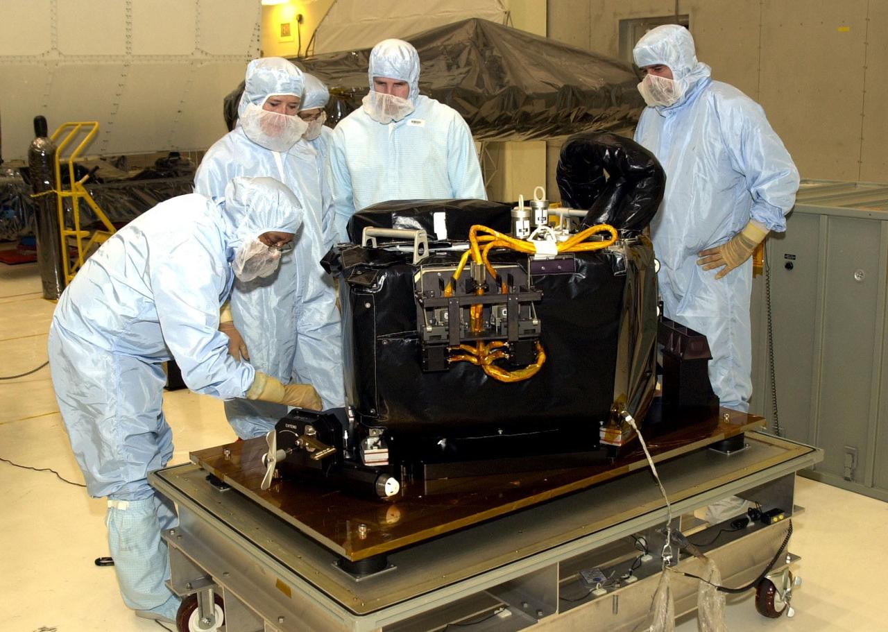 KENNEDY SPACE CENTER, FLA. -- Workers in the Vertical Processing Facility look over the Near Infrared Camera and Multi-Object Spectrometer (NICMOS) Cooling System, part of the payload on mission STS-109, the Hubble Servicing Telescope Mission. NICMOS is a new experimental cooling system consisting of a compressor and tiny turbines. With the experimental cryogenic system, NASA hopes to re-cool the infrared detectors to below -315 degrees F (-193 degrees Celsius). NICMOS II was previously tested aboard STS-95 in 1998. It could extend the life of the Hubble Space Telescope by several years. Astronauts aboard Columbia on mission STS-109 will be replacing the original NICMOS with the newer version. Launch of mission STS-109 is scheduled for Feb. 28, 2002