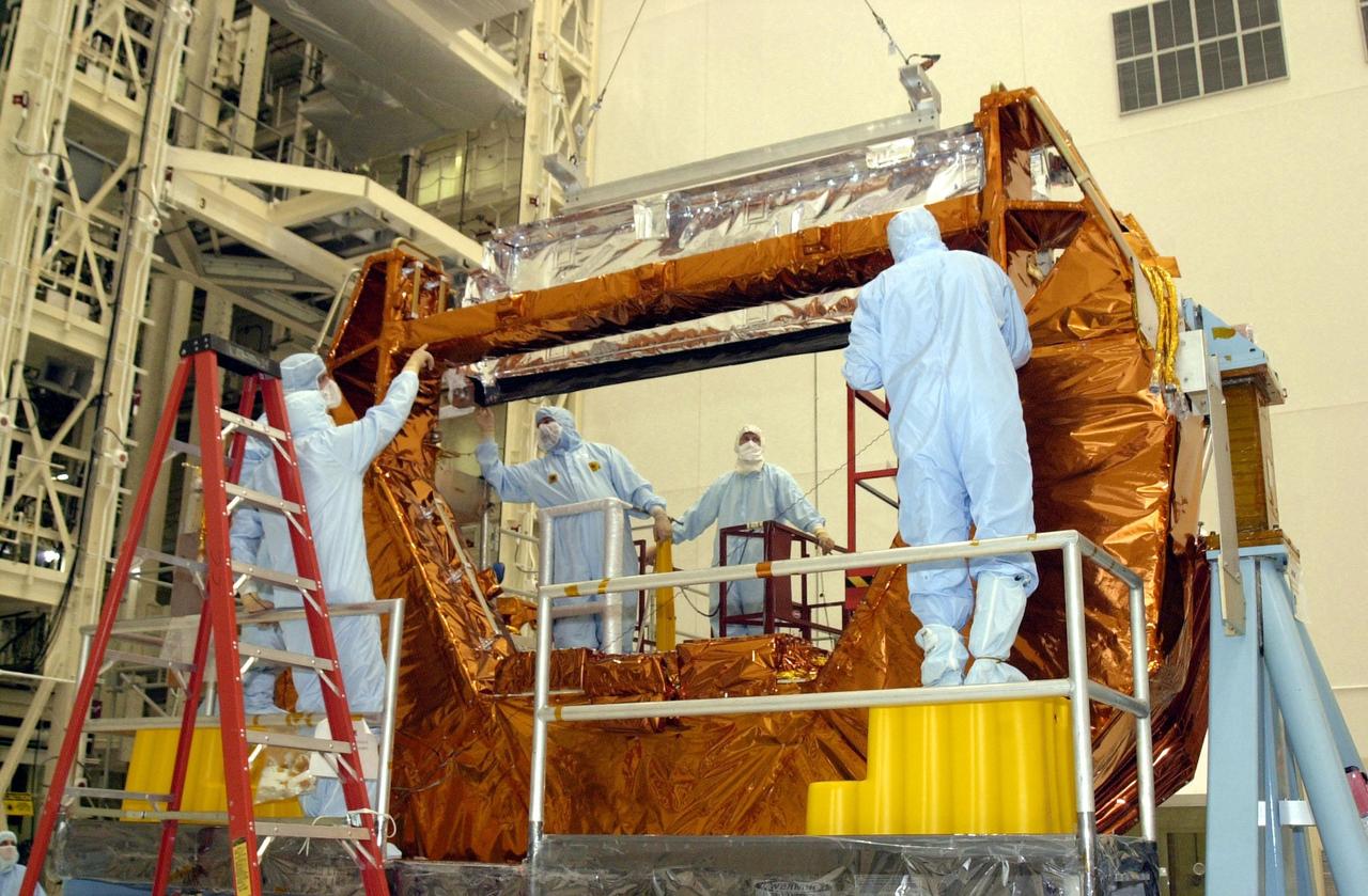KENNEDY SPACE CENTER, FLA. -- Workers in the Vertical Processing Facility oversee the installation of the NICMOS radiator onto the MULE (Multi-Use Lightweight Equipment) carrier. Part of the payload on mission STS-109, the Near Infrared Camera and Multi-Object Spectrometer (NICMOS) is a new experimental cooling system consisting of a compressor and tiny turbines. With the experimental cryogenic system, NASA hopes to re-cool the infrared detectors to below -315 degrees F (-193 degrees Celsius). NICMOS II was previously tested aboard STS-95 in 1998. NICMOS could extend the life of the Hubble Space Telescope by several years. Astronauts aboard Columbia on mission STS-109 will be replacing the original NICMOS with the newer version. Launch of Columbia on mission STS-109 is scheduled Feb. 28, 2002