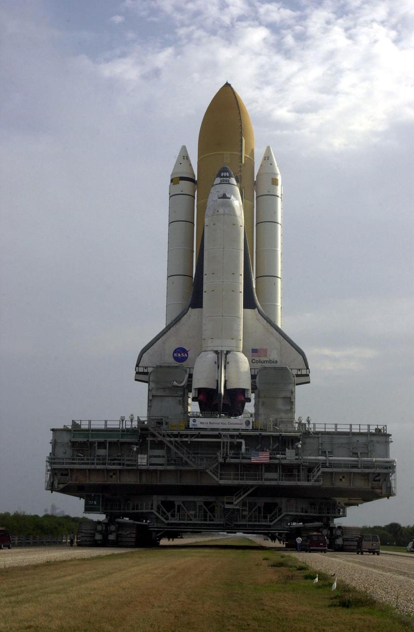 KENNEDY SPACE CENTER, FLA. --  A grey sky silhouettes Space Shuttle Columbia, atop its Mobile Launcher Platform, as it rolls out to Launch Pad 39A. Underneath is the crawler-transporter, which carries the multi-ton vehicles to the pad.   In the grass behind the towering structures are two white herons. Columbia is scheduled to be launched Feb. 28 on mission STS-109, a Hubble Servicing Mission. The goal of the mission is to replace Solar Array 2 with Solar Array 3, replace the Power Control Unit, remove the Faint Object Camera and install the ACS, install the Near Infrared Camera and Multi-Object Spectrometer (NICMOS) Cooling System, and install New Outer Blanket Layer insulation