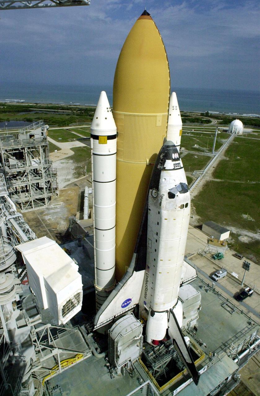 KENNEDY SPACE CENTER, FLA. -- Space Shuttle Columbia, atop its Mobile Launcher Platform, sits on Launch Pad 39A after an early morning rollout from the Vehicle Assembly Building. In the distance is seen the Atlantic Ocean. To the left is the "White Room" that provides entry to the cockpit when extended to the orbiter. The environmentally controlled room is at the end of the Orbiter Access Arm, located 147 feet above the pad, on the Fixed Service Structure. Columbia is scheduled to be launched Feb. 28 on mission STS-109, a Hubble Servicing Mission. The goal of the mission is to replace Solar Array 2 with Solar Array 3, replace the Power Control Unit, remove the Faint Object Camera and install the ACS, install the Near Infrared Camera and Multi-Object Spectrometer (NICMOS) Cooling System, and install New Outer Blanket Layer insulation. The launch will be the first for Columbia after returning from California where it underwent extensive maintenance, inspections and enhancements. More than 100 upgrades make Columbia safer and more reliable than ever before