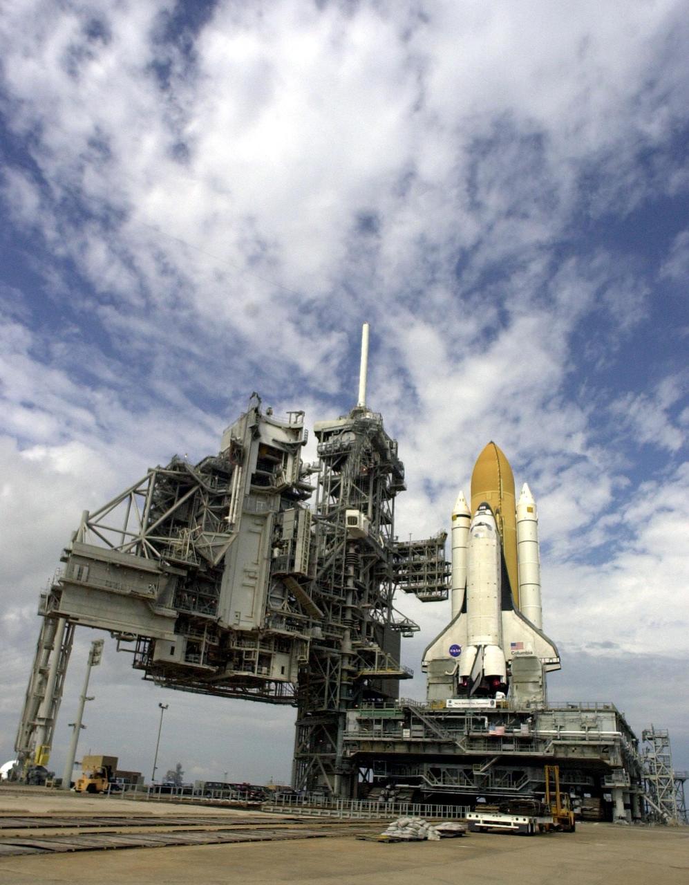 KENNEDY SPACE CENTER, FLA. -- Space Shuttle Columbia, atop its Mobile Launcher Platform, sits on Launch Pad 39A after an early morning rollout from the Vehicle Assembly Building.  On the left is the Rotating Service Structure, which will swing counterclockwise to enclose the Shuttle and enable final preparations, including transfer of the payload.  Atop the Fixed Service Structure (center) is the lightning mast, 347 feet above the pad.  The 80-foot fiberglass mast provides protection from lightning strikes. Columbia is scheduled to be launched Feb. 28 on mission STS-109, a Hubble Servicing Mission. The goal of the mission is to replace Solar Array 2 with Solar Array 3, replace the Power Control Unit, remove the Faint Object Camera and install the ACS, install the Near Infrared Camera and Multi-Object Spectrometer (NICMOS) Cooling System, and install New Outer Blanket Layer insulation.  The launch will be the first for Columbia after returning from California where it underwent extensive maintenance, inspections and enhancements. More than 100 upgrades make Columbia safer and more reliable than ever before