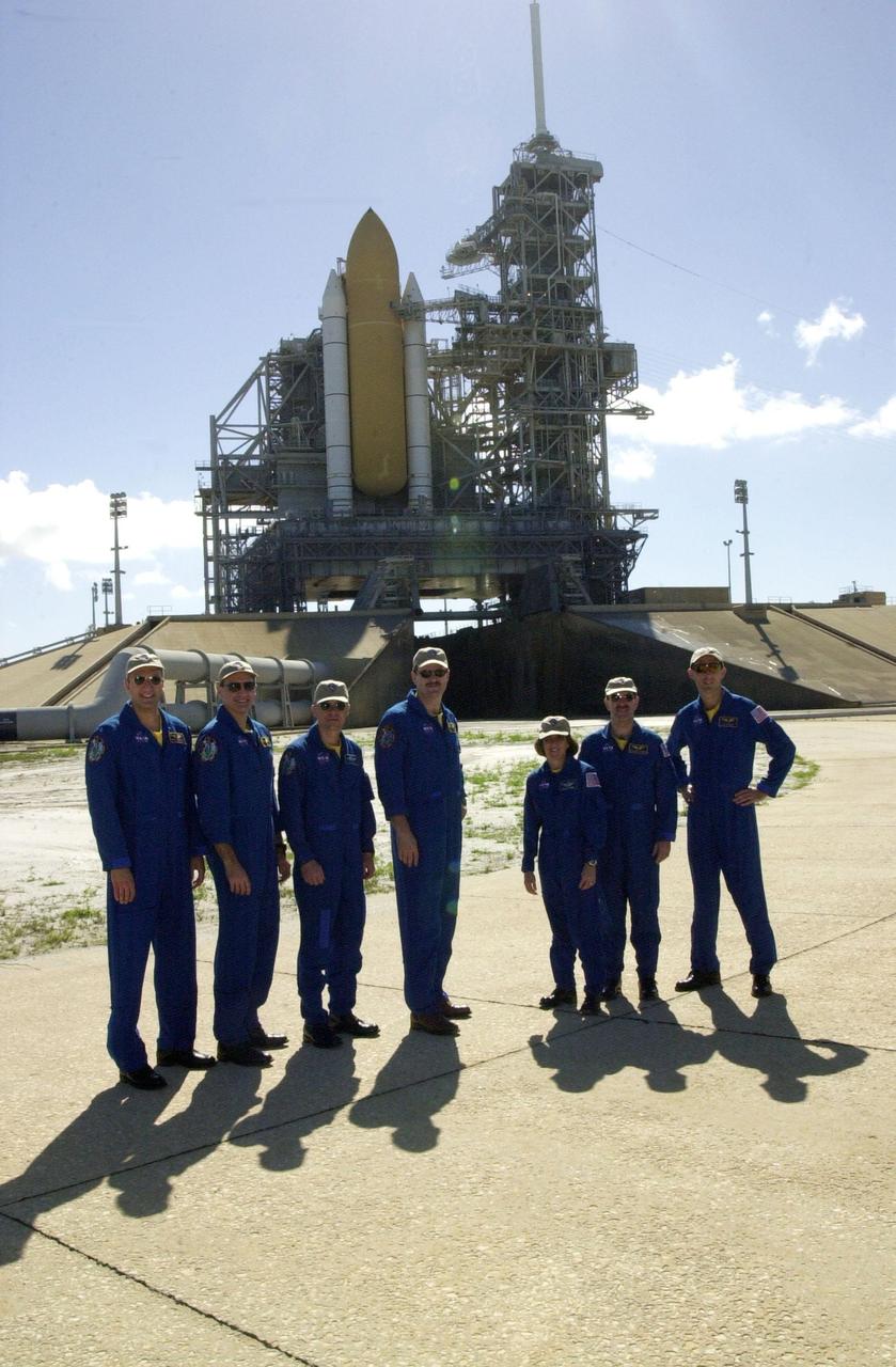 KENNEDY SPACE CENTER, FLA. --   The STS-109 crew poses for a photo at Launch Pad 39A during a break in training.  From left are Mission Specialists Michael Massimino and Richard Linnehan, Pilot Duane Carey, Commander Scott Altman, and Mission Specialists Nancy Currie, John Grunsfeld and James Newman.  Grunsfeld is also Payload Commander on the mission. The crew is taking part in Terminal Countdown Demonstration Test activities that include emergency egress training and a simulated countdown at the pad.  Columbia is scheduled to be launched Feb. 28 on mission STS-109, a Hubble Servicing Mission. The goal of the mission is to replace Solar Array 2 with Solar Array 3, replace the Power Control Unit, remove the Faint Object Camera and install the ACS, install the Near Infrared Camera and Multi-Object Spectrometer (NICMOS) Cooling System, and install New Outer Blanket Layer insulation.  In the background can be seen the external tank flanked by the twin solid rocket boosters that will propel Columbia (unseen on the other side of the stack) into space.  The launch will be the first for Columbia after returning from California where it underwent extensive maintenance, inspections and enhancements. More than 100 upgrades make Columbia safer and more reliable than ever before