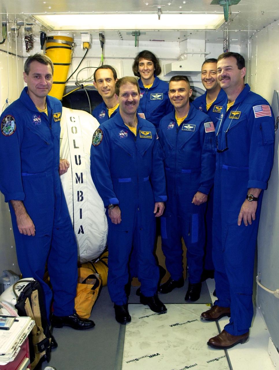 KENNEDY SPACE CENTER, FLA. --  At Launch Pad 39A, the STS-109 crew stands in the White Room, outside the entry into Space Shuttle Columbia.  Standing, left to right, are Mission Specialists Richard Linnehan, James Newman, John Grunsfeld and Nancy Currie; Pilot Duane Carey; Mission Specialist Michael Massimino; and Commander Scott Altman.  The White Room is an environmentally controlled structure at the end of the Orbiter Access Room that provides access to the orbiter. The crew is taking part in Terminal Countdown Demonstration Test activities that include emergency egress training and a simulated countdown at the pad.  Columbia is scheduled to be launched Feb. 28 on mission STS-109, a Hubble Servicing Mission. The goal of the mission is to replace Solar Array 2 with Solar Array 3, replace the Power Control Unit, remove the Faint Object Camera and install the ACS, install the Near Infrared Camera and Multi-Object Spectrometer (NICMOS) Cooling System, and install New Outer Blanket Layer insulation. .  The launch will be the first for Columbia after returning from California where it underwent extensive maintenance, inspections and enhancements. More than 100 upgrades make Columbia safer and more reliable than ever before