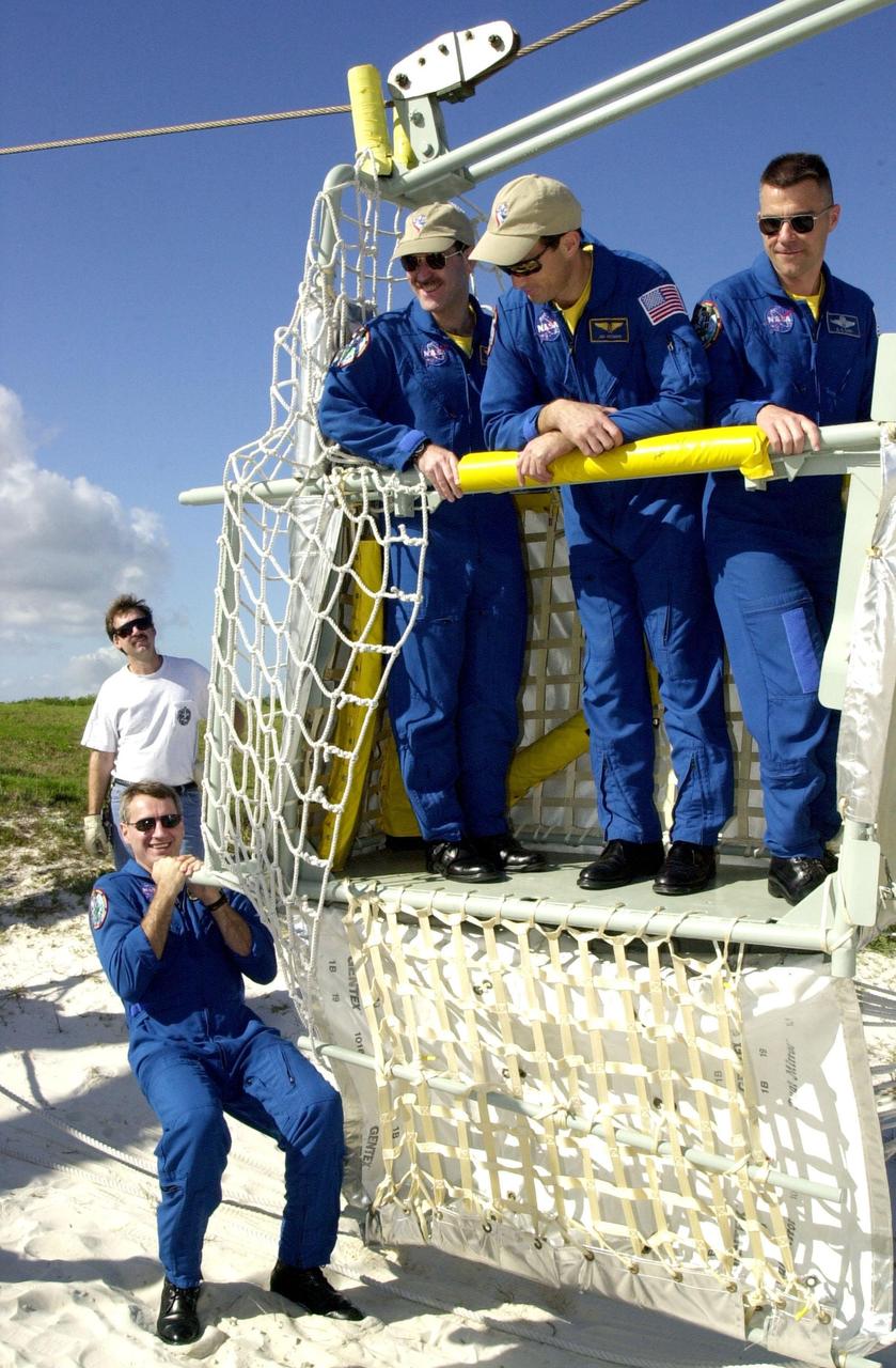 KENNEDY SPACE CENTER, FLA. -- Near the bunker at the bottom of Launch Pad 39A, Mission Specialist Richard Linnehan steadies the slidewire basket, part of the emergency egress system from the orbiter. In the basket are Mission Specialists John Grunsfeld and James Newman and Pilot Duane Carey. The training is part of Terminal Countdown Demonstration Test activities that include a simulated countdown at the pad. Columbia is scheduled to be launched Feb. 28 on mission STS-109, a Hubble Servicing Mission. The goal of the mission is to replace Solar Array 2 with Solar Array 3, replace the Power Control Unit, remove the Faint Object Camera and install the ACS, install the Near Infrared Camera and Multi-Object Spectrometer (NICMOS) Cooling System, and install New Outer Blanket Layer insulation. . The launch will be the first for Columbia after returning from California where it underwent extensive maintenance, inspections and enhancements. More than 100 upgrades make Columbia safer and more reliable than ever before