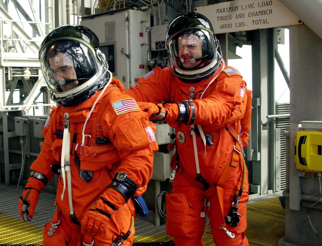 KENNEDY SPACE CENTER, FLA. -- As part of Terminal Countdown Demonstration Test activities, the STS-109 crew practices emergency exit from the Shuttle. Leading the way to the slidewire basket on the 195-foot level is Pilot Duane Carey, followed by Commander Scott Altman. The TCDT also includes a simulated launch countdown. STS-109 is a Hubble Space Telescope Servicing Mission, with goals to replace Solar Array 2 with Solar Array 3, replace the Power Control Unit, remove the Faint Object Camera and install the Advanced Camera for Surveys (ACS), install the Near Infrared Camera and Multi-Object Spectrometer (NICMOS) Cooling System, and install New Outer Blanket Layer insulation. The 11-day mission will require five spacewalks to perform the tasks. Launch of STS-109 aboard Space Shuttle Columbia is scheduled for Feb. 28, 2002