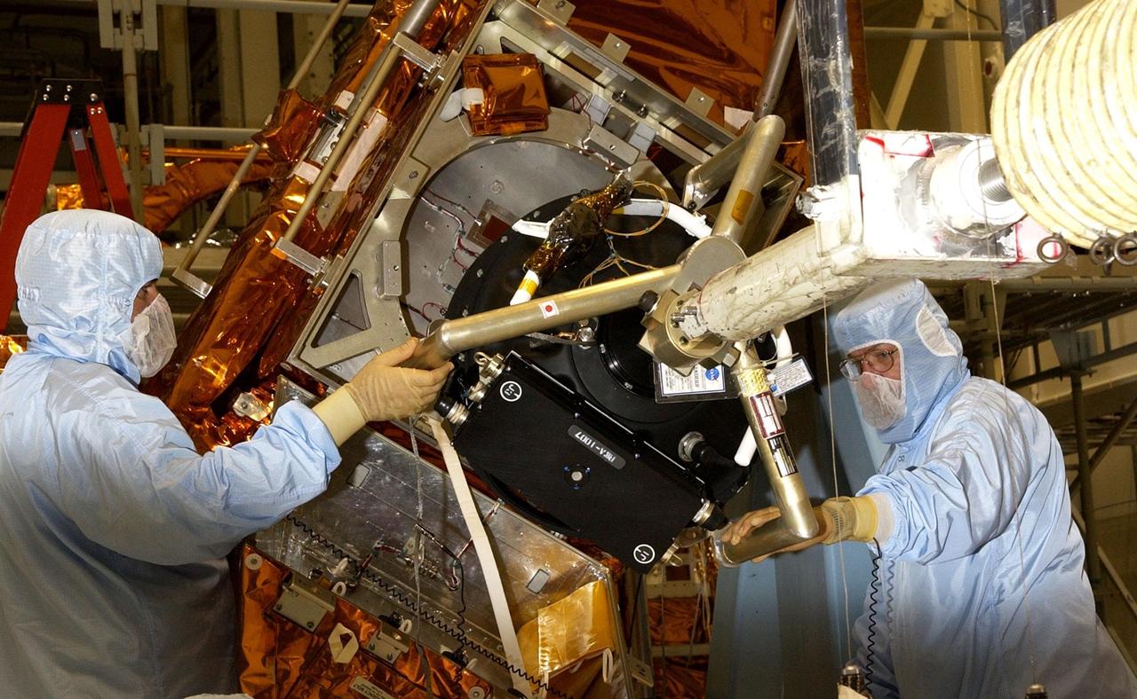 KENNEDY SPACE CENTER, FLA. - Workers in the Vertical Processing Facility maneuver the replacement Reaction Wheel Actuator for the Hubble Space Telescope into position on the Large Orbital Protective Enclosure (LOPE), which is contained in the Multi-Use Lightweight Equipment (MULE) for flight. Part of Hubble's Pointing Control System, the actuators receiving information from sensors and physically adjust Hubble's position and orientation so that Hubble can view the required celestial bodies. The reaction wheels work by rotating a large flywheel up to 3000 rpm or braking it to exchange momentum with the spacecraft which will make Hubble turn. The RWA is part of the payload on mission STS-109, the Hubble Servicing Mission, scheduled to launch Feb. 28, 2002
