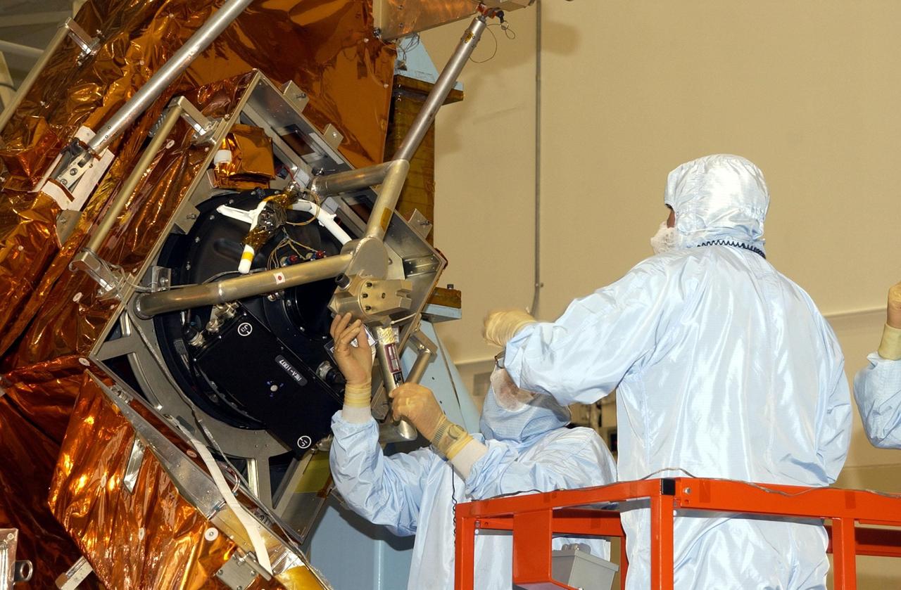 KENNEDY SPACE CENTER, FLA. -- Workers in the Vertical Processing Facility check the attachment of the the Hubble Space Telescope's replacement Reaction Wheel Actuator on the Large Orbital Protective Enclosure (LOPE), which is contained in the Multi-Use Lightweight Equipment (MULE) for flight. Part of Hubble's Pointing Control System, the actuators receiving information from sensors and physically adjust Hubble's position and orientation so that Hubble can view the required celestial bodies. The reaction wheels work by rotating a large flywheel up to 3000 rpm or braking it to exchange momentum with the spacecraft which will make Hubble turn. The RWA is part of the payload on mission STS-109, the Hubble Servicing Mission, scheduled to launch Feb. 28, 2002