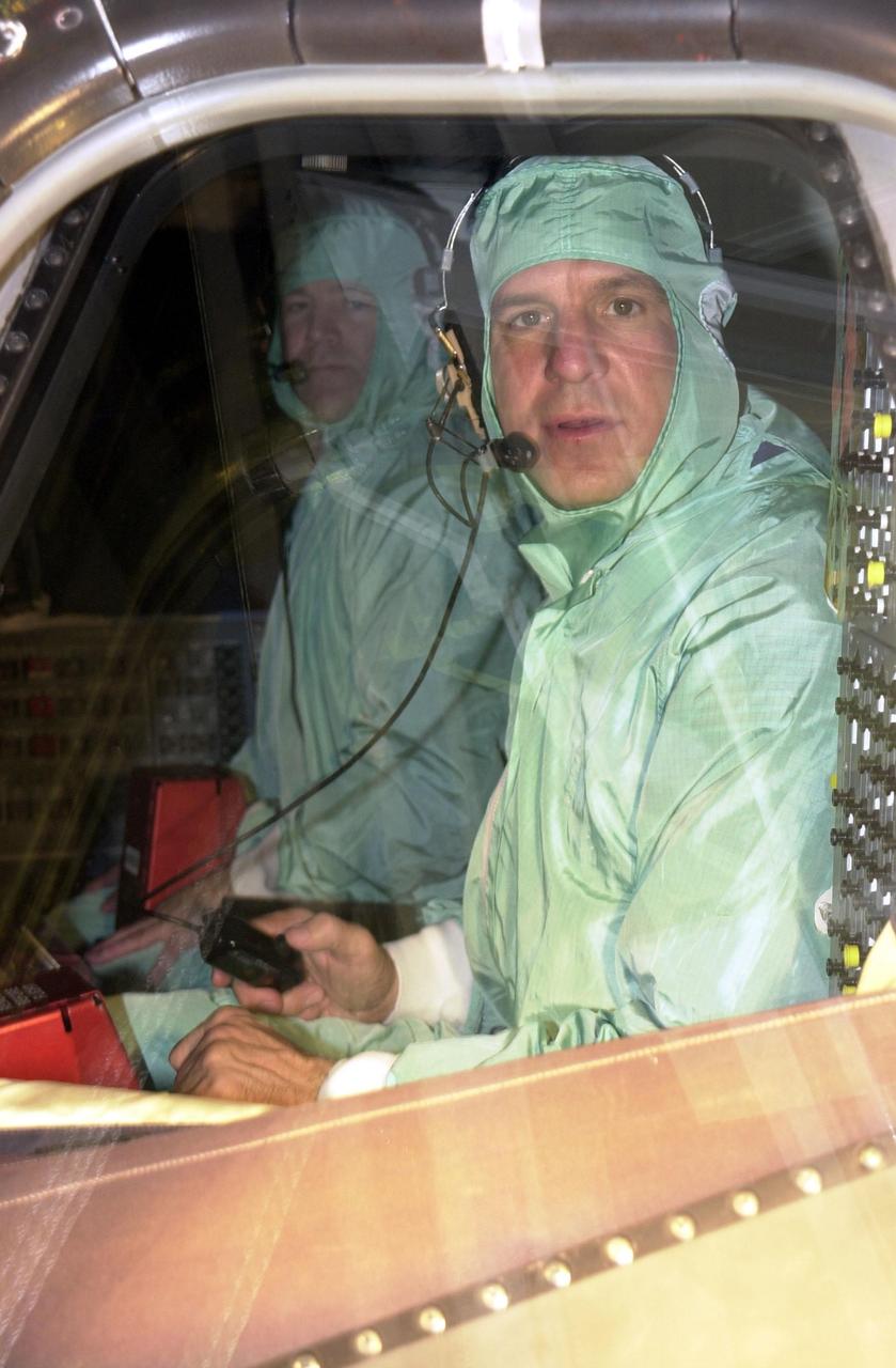 KENNEDY SPACE CENTER, FLA. -- In the Orbiter Processing Facility, STS-110 Commander Michael Bloomfield checks out a window in the cockpit of Atlantis during Crew Equipment Integration Test activities.  The mission, 13th assembly flight to the International Space Station, includes the Integrated Truss Structure S0.    The ITS S0 is the center segment on the Space Station, part of the 300-foot (91-meter) truss attached to the U.S. Lab. By assembly completion, four more truss segments will attach to either side of the S0 truss.  STS-110 is scheduled to launch April 4, 2002