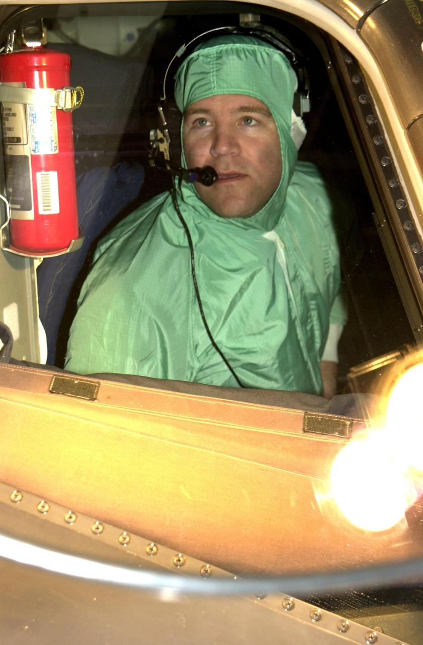 KENNEDY SPACE CENTER, FLA. -- In the Orbiter Processing Facility, STS-110 Pilot Stephen Frick checks a window in the cockpit of Atlantis during Crew Equipment Integration Test activities.  The mission, 13th assembly flight to the International Space Station, includes the Integrated Truss Structure S0.    The ITS S0 is the center segment on the Space Station, part of the 300-foot (91-meter) truss attached to the U.S. Lab. By assembly completion, four more truss segments will attach to either side of the S0 truss.  STS-110 is scheduled to launch April 4, 2002