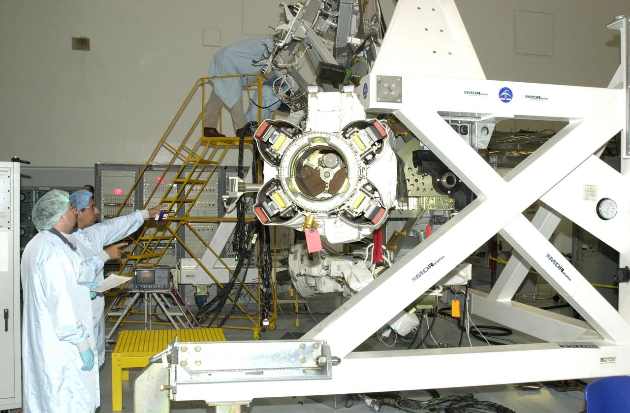 KENNEDY SPACE CENTER, FLA. -- Workers in the Space Station Processing Facility look over the Mobile Base System (MBS), part of the payload on mission STS-111 to the International Space Station. The MBS will be installed on the Mobile Transporter to complete the Canadian Mobile Servicing System, or MSS. The mechanical arm will then have the capability to "inchworm" from the U.S. Lab Destiny to the MSS and travel along the truss to work sites. STS-111 is the second utilization flight (UF-2) to the Space Station and will also carry the Expedition 5 crew to replace Expedition 4. Launch is scheduled for May 2, 2002
