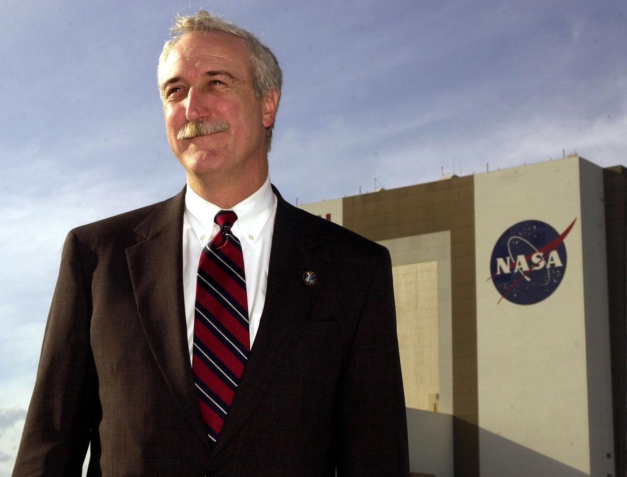 KENNEDY SPACE CENTER, Fla. - The new NASA Administrator Sean O'Keefe poses for the photographer with the Vehicle Assembly Building in the background. The administrator was at KSC on an agencywide familiarization tour of NASA field centers. He was nominated for the position as administrator in November 2001 by President George W. Bush. He was sworn in Dec. 21 as the agency's tenth chief