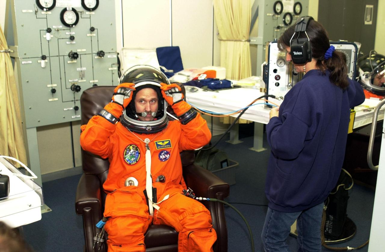 KENNEDY SPACE CENTER, Fla. - STS-109 Payload Commander John M. Grunsfeld gets a final fitting on his launch and entry suit two days before launch.  On mission STS-109, the seven-member crew will capture the Hubble Space Telescope using the Shuttle's robotic arm and secure it on a workstand in Columbia's payload bay.  Four mission specialists will perform five scheduled spacewalks to complete system upgrades to the telescope. More durable solar arrays, a large gyroscopic assembly to help point the telescope properly, a new telescope power control unit, and a cooling system to restore the use of a key infrared camera and spectrometer unit, which has been dormant since 1999, will all be installed.  In addition, the telescope’s view of the Universe will be improved with the addition of the Advanced Camera for Surveys (ACS), which replaces the Faint Object Camera, the last of Hubble's original instruments.  The STS-109 crew also includes Commander Scott D. Altman, Pilot Duane G. Carey, and Mission Specialists James H. Newman, Nancy J. Currie, Richard M. Linnehan and Michael J. Massimino.  Launch is scheduled for Feb. 28, 2002, at 6:48 a.m. EST (11:48 GMT)