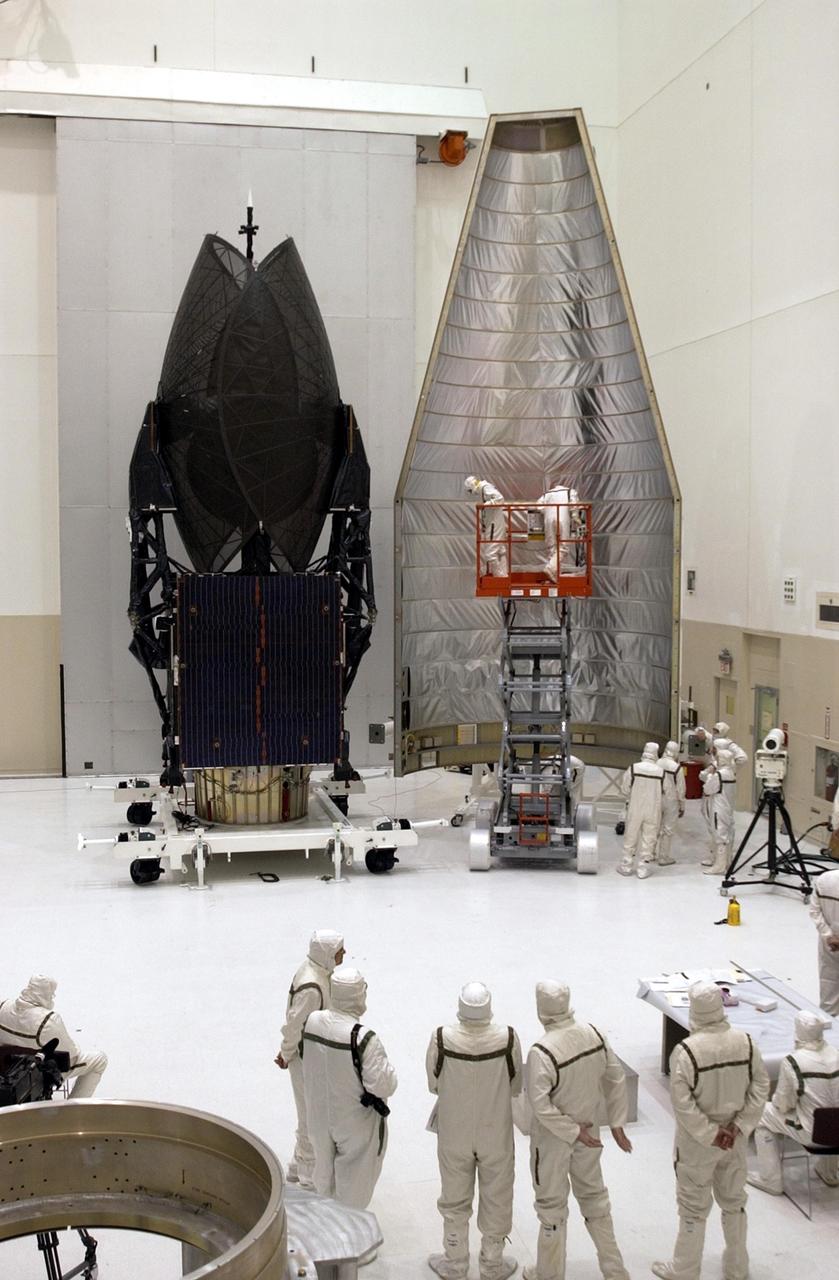 KENNEDY SPACE CENTER, FLA. -- In the Spacecraft Assembly and Encapsulation Facility-2 (SAEF-2), the Tracking and Data Relay Satellite-I (TDRS-I) (left) waits for encapsulation in the first half  of the nose fairing , in preparation for launch. The second in a new series of telemetry satellites, TDRS-I replenishes the existing on-orbit fleet of six spacecraft. The TDRS System is the primary source of space-to-ground voice, data and telemetry for the Space Shuttle. It also provides communications with the International Space Station and scientific spacecraft in low-Earth orbit such as the Hubble Space Telescope. This new advanced series of satellites will extend the availability of TDRS communications services until about 2017. Launch of TDRS-I is scheduled for March 8 aboard a Lockheed Martin Atlas IIA rocket from Pad 36-A, Cape Canaveral Air Force Station